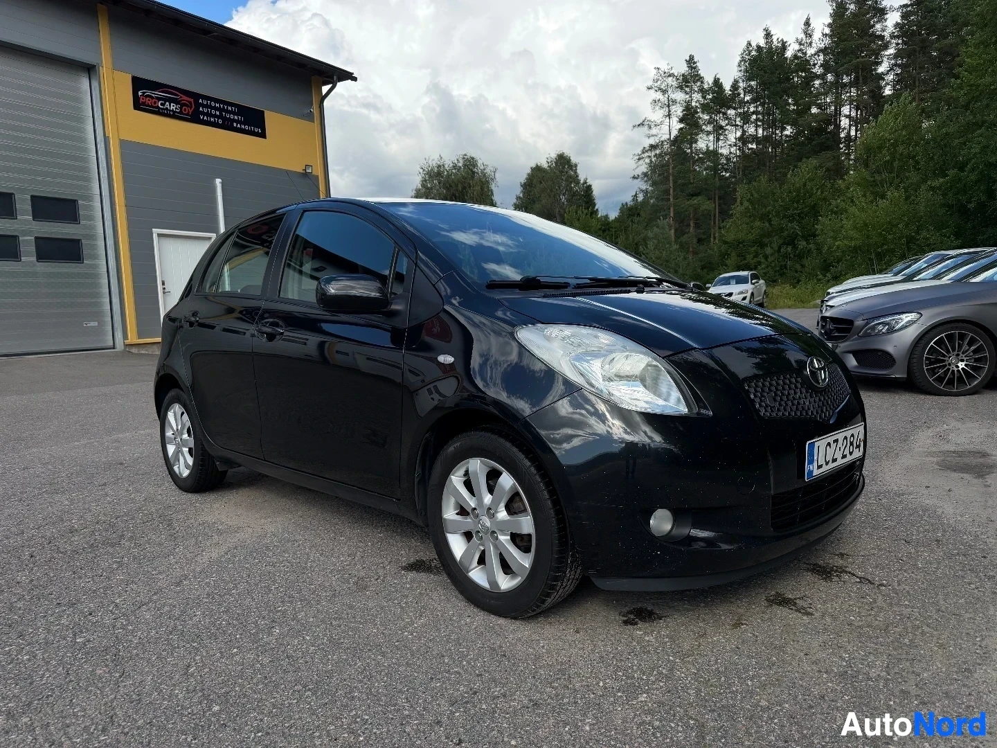 Black Toyota Yaris front three-quarter view in dealer lot
