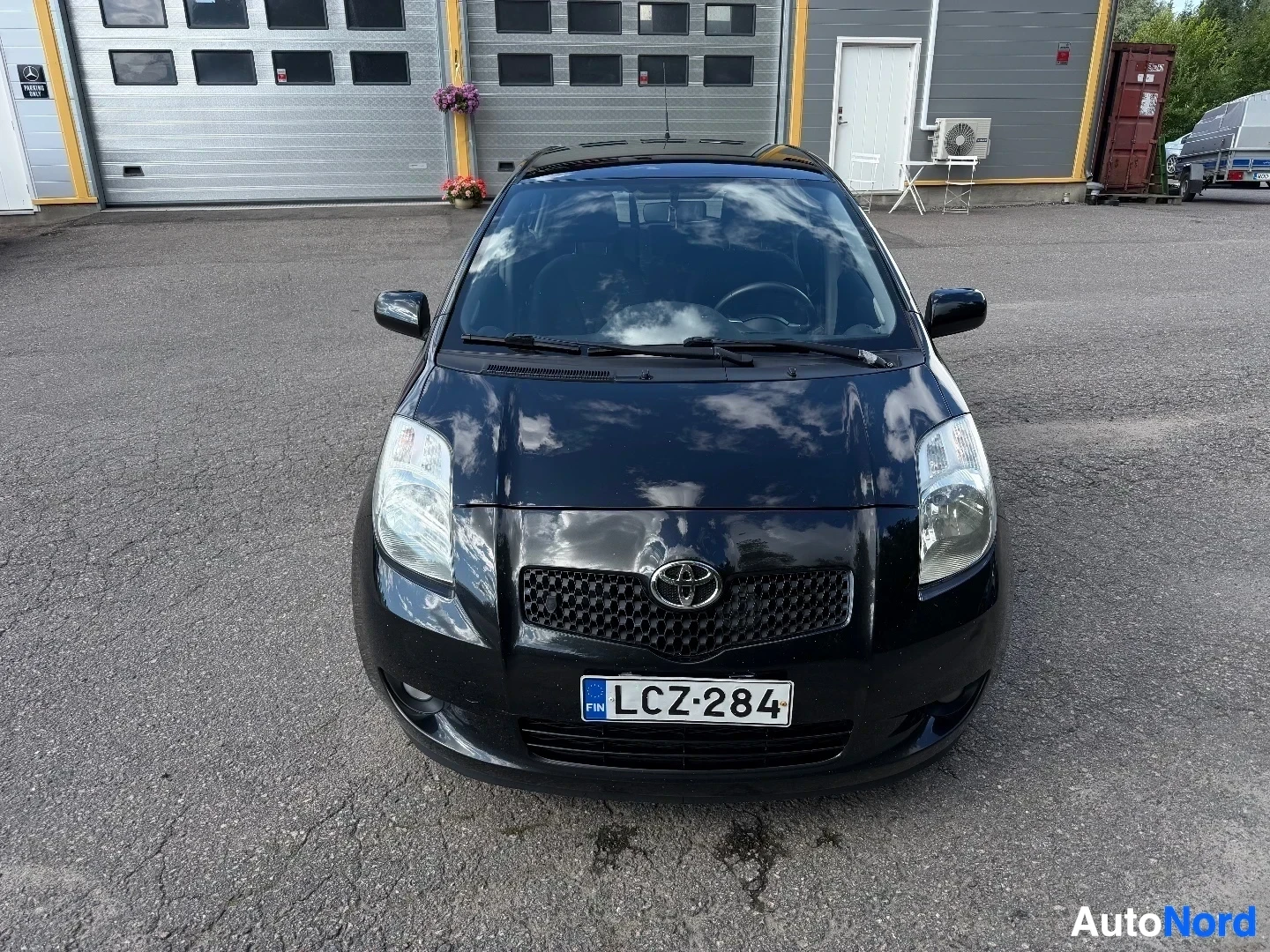 Black Toyota Yaris front view showing headlights, grille, and registration plate