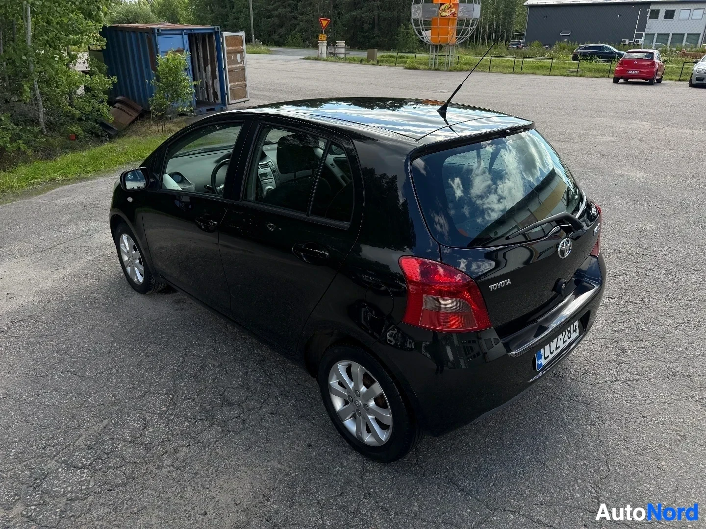 Black Toyota Yaris five-door hatchback, rear three-quarter view in parking lot