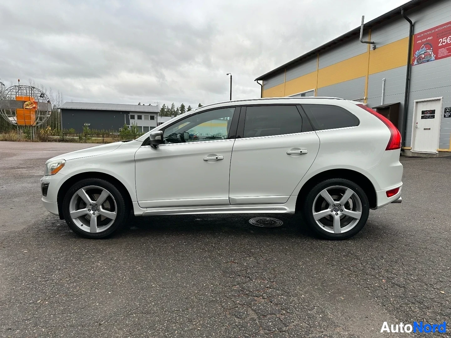 Valkoinen Volvo XC60 sivusta katsottuna punaisten takavalojen näkyvillä