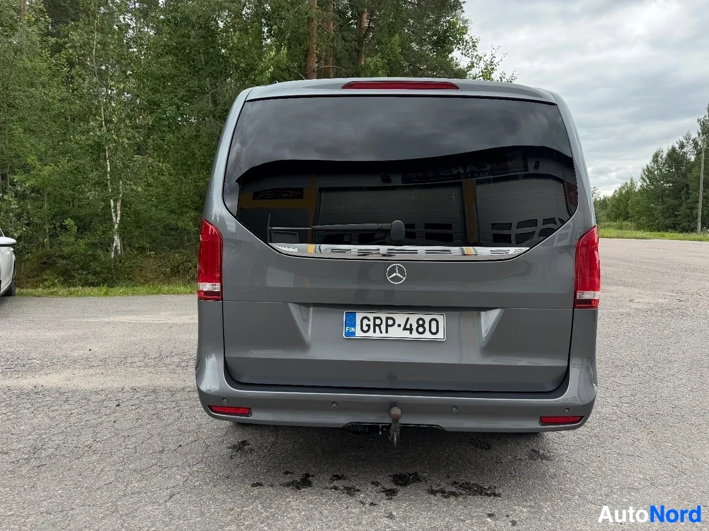 Rear view of gray Mercedes-Benz van with open tailgate and registration plate