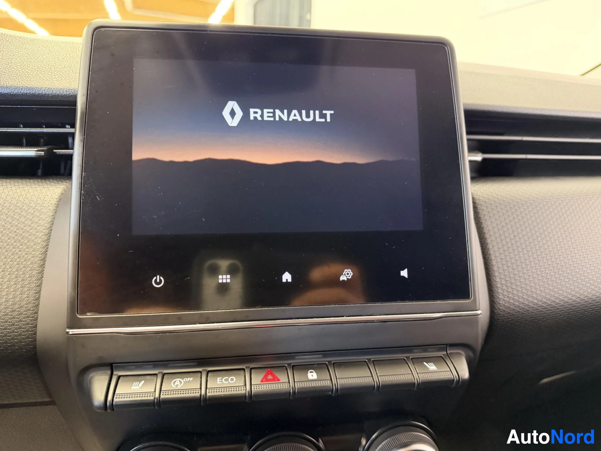 Yksityiskohta: Auton kosketusnäyttö käynnistysruudulla, Renault-logo näytöllä, alla ohjainpainikkeet ja ECO-tila painike