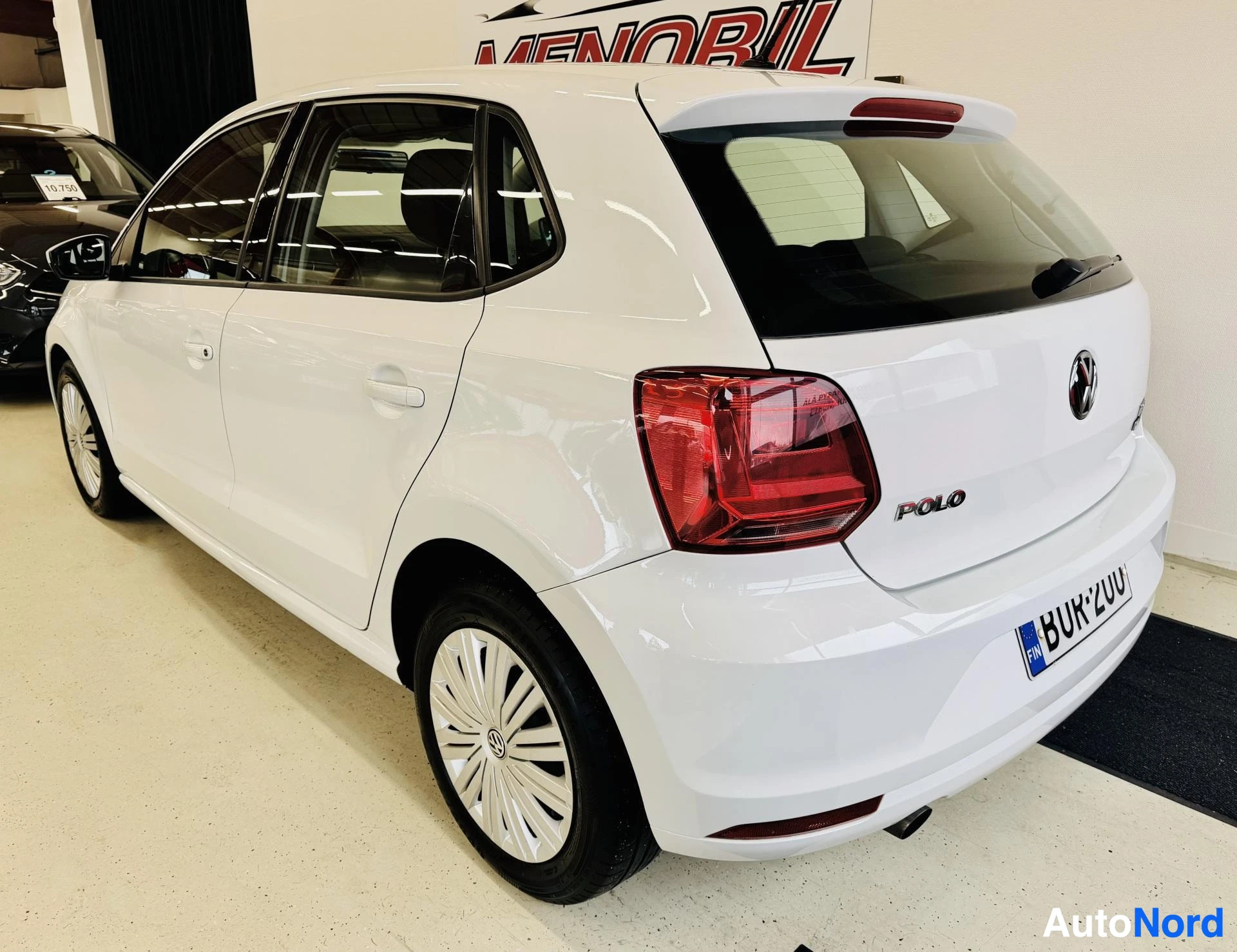 Takaviisto: Valkoinen Volkswagen Polo takaa-puolelta, punaisia takavaloseja, POLO-teksti takalevyssä näkyvissä, rekisterikilpi BUK: alkuisella, valkoisia vanteet