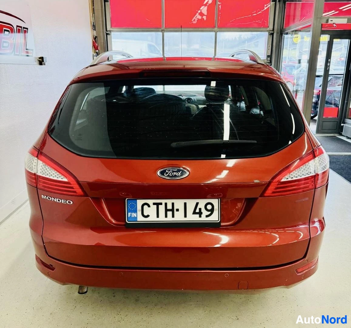 Takaa: Punainen Ford Mondeo -paketivaunu takaapäin kuvattuna, näkyy Ford-logo, MONDEO-teksti, rekisterikilvessa CTH149