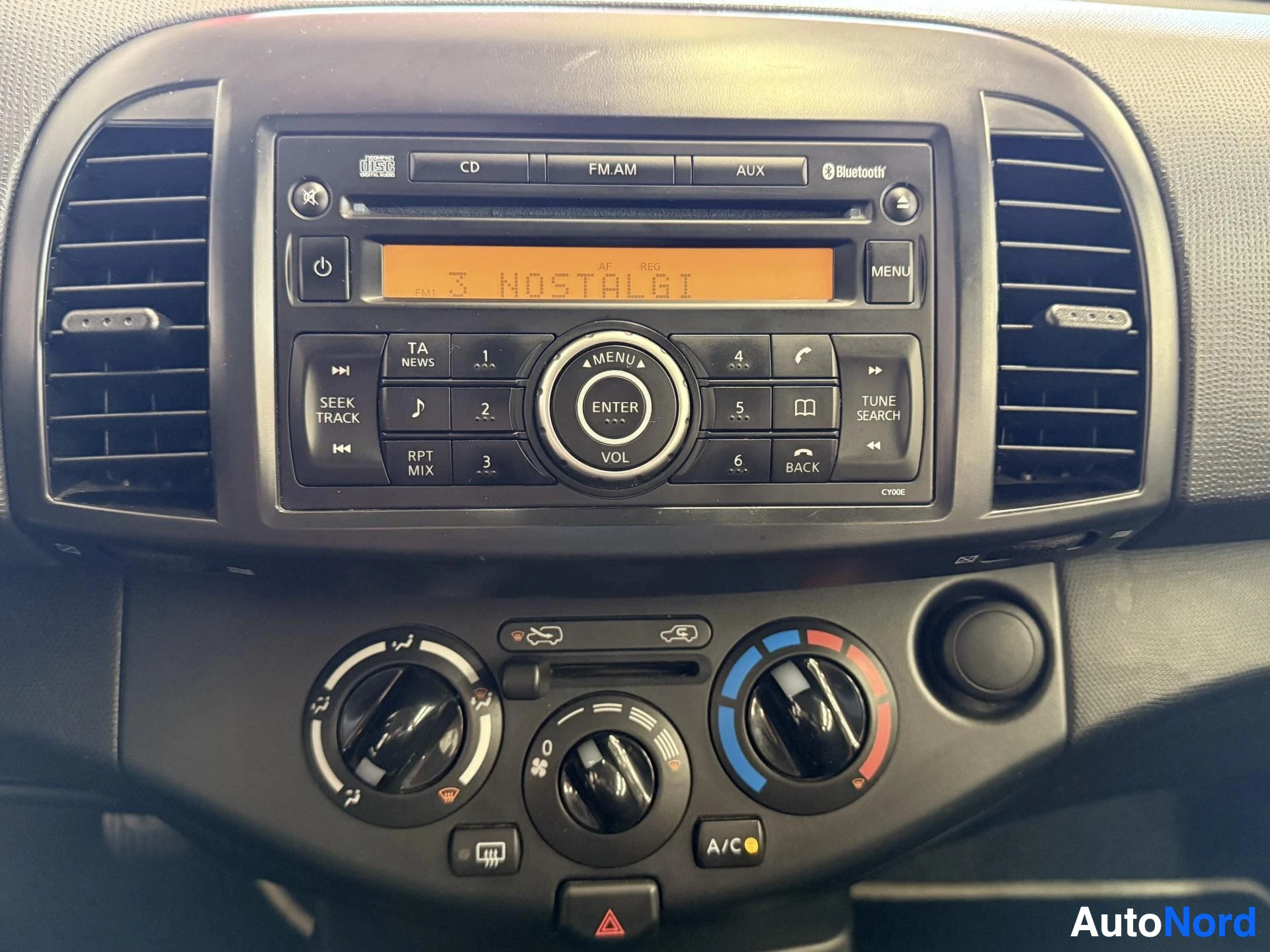 Yksityiskohta: Auton radioyksikkö lähikuvassa, näkyvät CD-soitin, FM/AM-radio, AUX-liitäntä ja Bluetooth
