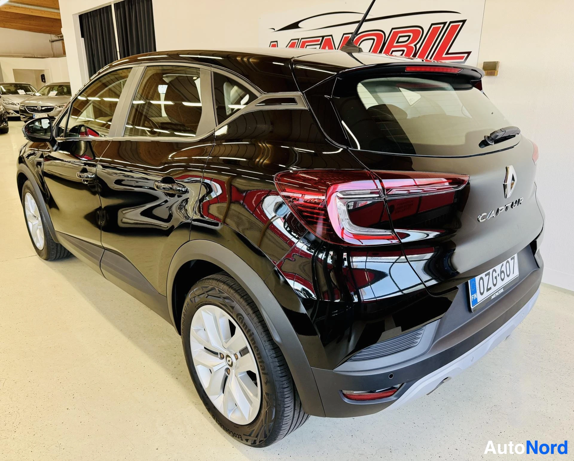 Takaviisto: Musta Renault Captur, takanäkymä kolmekolmanneksen kulmasta, näkyvät takaa ja vasen sivu, valkoiset vanteet, punaiset takavalaistukset, rekisteritunnus OZ76G07,