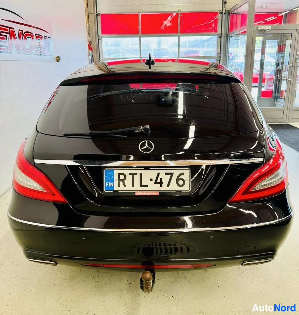 Takaa: Musta Mercedes-Benz CLS viistoperän taka-ovi suljettu, punainen takavalolinssi näkyvissä, rekisterinumero sinisen EU-lipun kanssa, aiemmat säleiköt näky