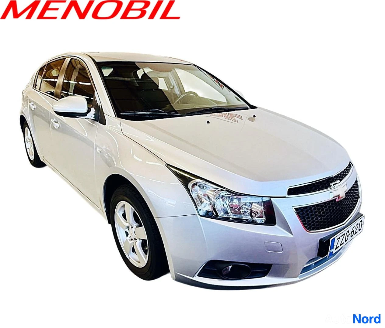 Etuviisto, nokka oikealle: Valkoinen Chevrolet Cruze, etupuolen kolmivieruskuva oikealle osoittavasta kulmasta, valkoinen tausta. Etulasit osittain auki, kultalanganväriset vanteet