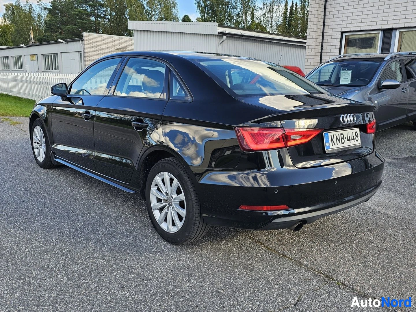 Takaviisto: Musta Audi A3 Sedan takaviistosta kuvattuna ulkona parkkipaikalla. Takavalot ja rekisterikilpi näkyvät.