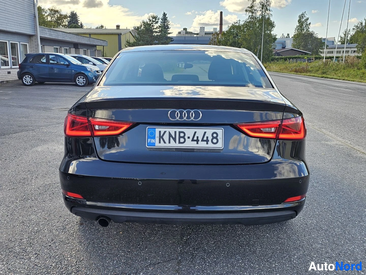 Takaa: Musta Audi A3 Sedan suoraan takaa päin kuvattuna parkkipaikalla. Rekisterikilpi ja takavalot näkyvät.