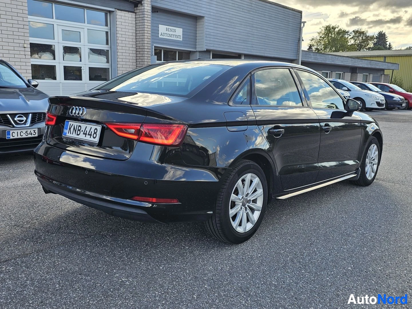 Takaviisto: Musta Audi A3 Sedan takaviistosta vasemmalta puolelta kuvattuna parkkipaikalla. Rekisterikilpi on.
