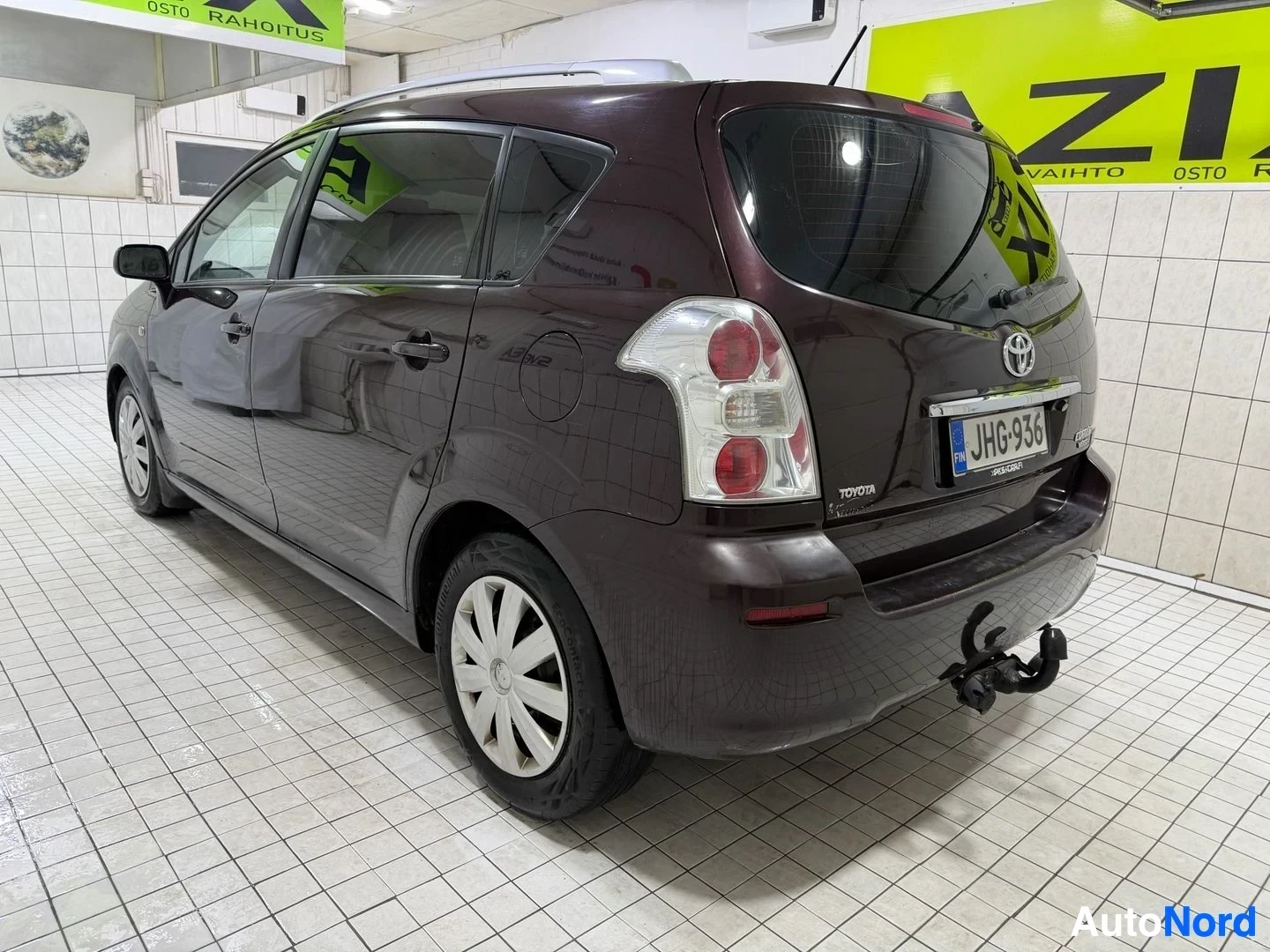 Takaviisto: Tummanruskea Toyota -tila-auto takaviistosta oikealla puolella, näkyy perä ja takalasi kylmävaraston sisällä