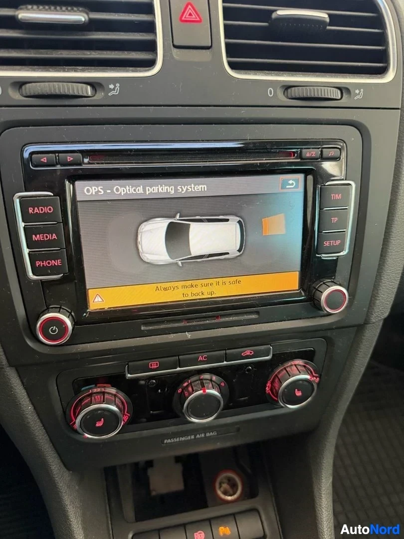 Ohjaamo: Auton sisustus näyttää infotainment-järjestelmän näyttöä, jossa näkyy optisen pysäköintijärjestelmän (OPS) näkymä ylhäältä. Näytöllä näkyy valkoinen auto ylhääl