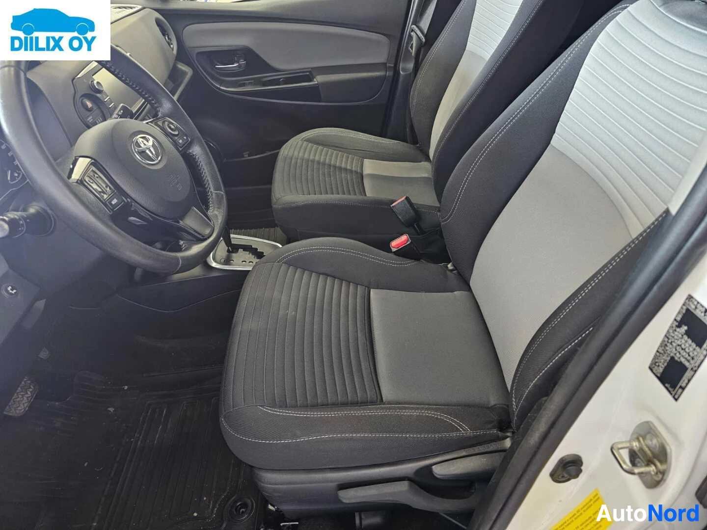 Etuistuimet: Etupaikat sisältä, käyttäjän puoli, mustalla ja harmaalla verhoilulla, Toyota-ratti, käsituet punaisella painikkeella