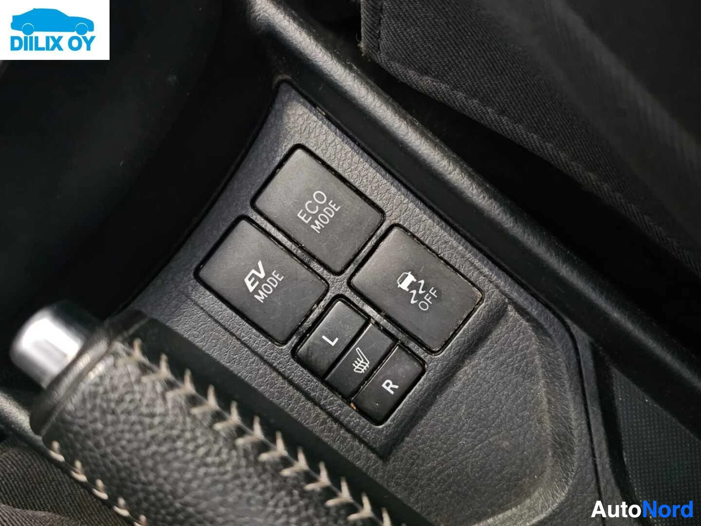 Yksityiskohta: Auton sisäänrakennetun ohjauslaitteen painikkeet: ECO MODE, EV MODE, i-stop ja Learning and Assist painikkeet mustan monitaajuisen ohjauspyörän yläpuolella