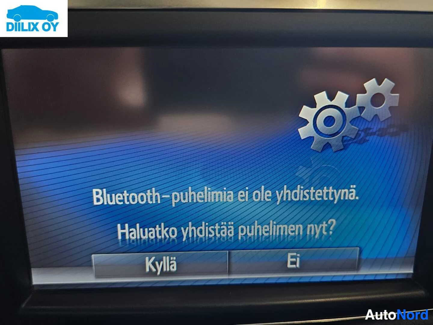 Yksityiskohta: Automonitorin näyttö sinisellä taustalla näyttää viesti Bluetooth-yhteyden perustamisesta. Teksti 'Bluetooth-puhelimia ei ole yhdistetty. Haluatko yhdistää puhe