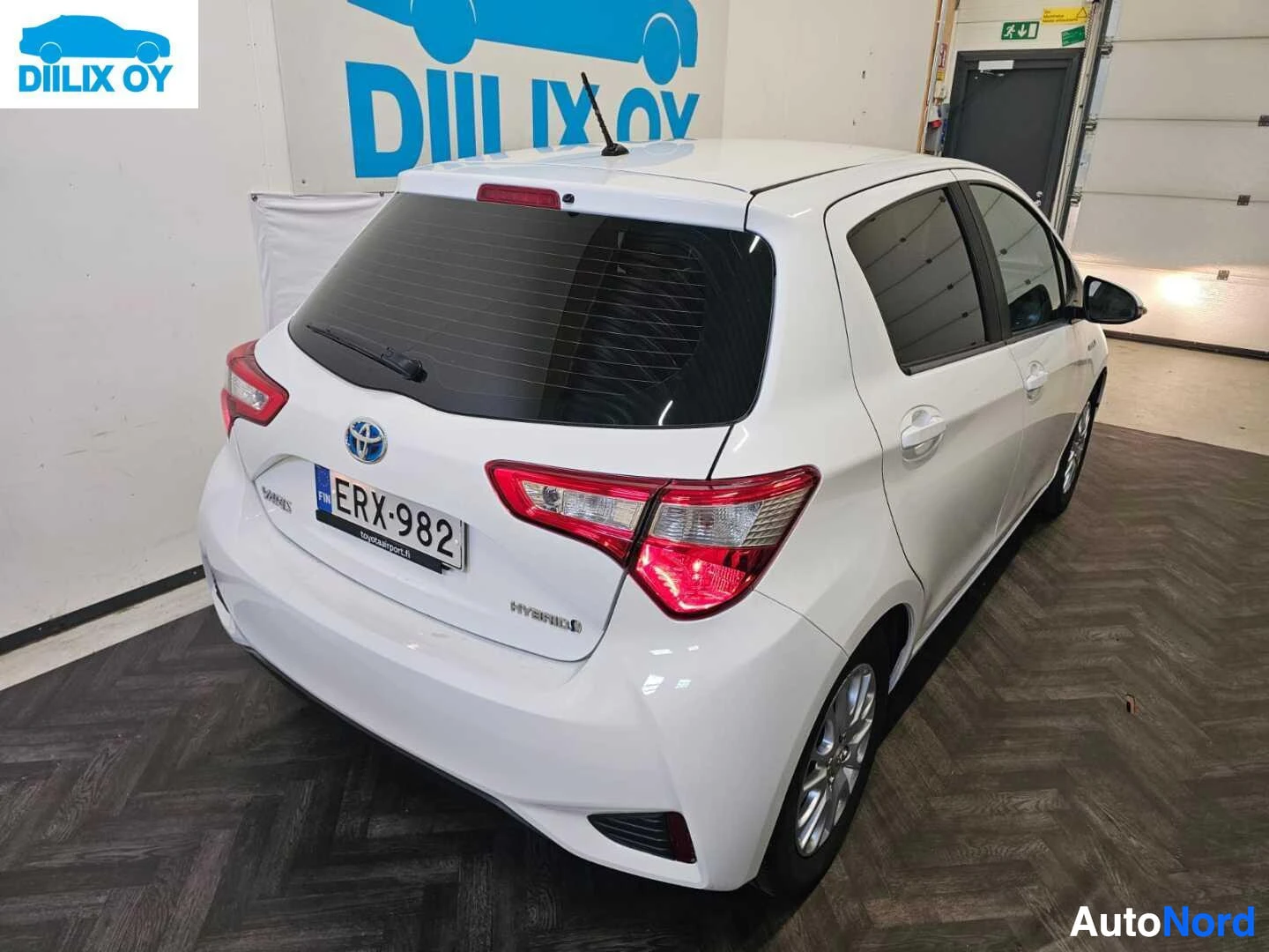 Takaa: Valkoinen pieni nelivetohybridi-auto takaa; näkyvissä rekisterikyltti, LED-takavalot ja hybridi-merkintä takaovessa