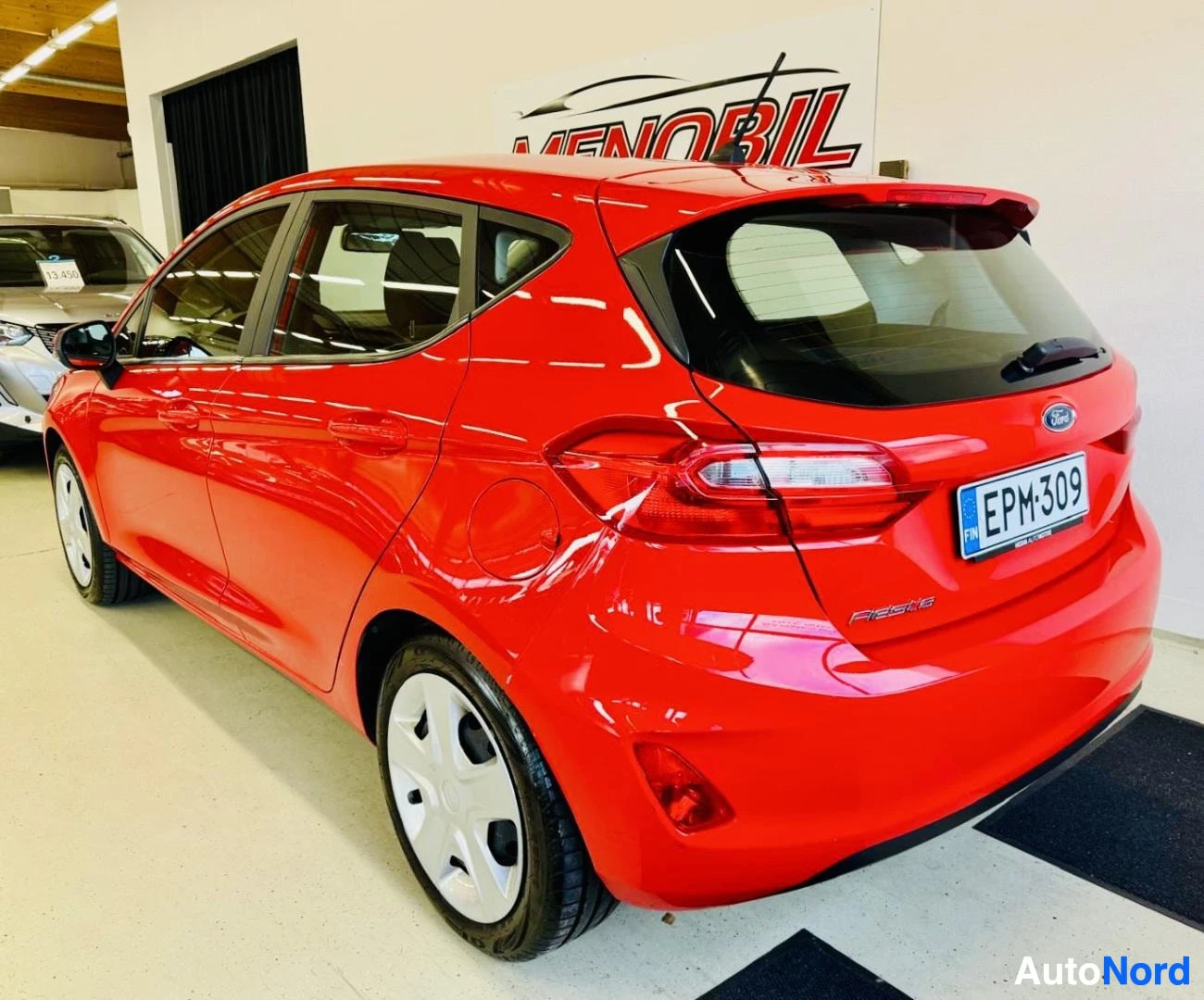 Takaviisto: Punainen Ford Fiesta takaosan kolmen neljänneksen näkymä, kuvattu varastolla, rekisterikilvessä teksti EPM309.
