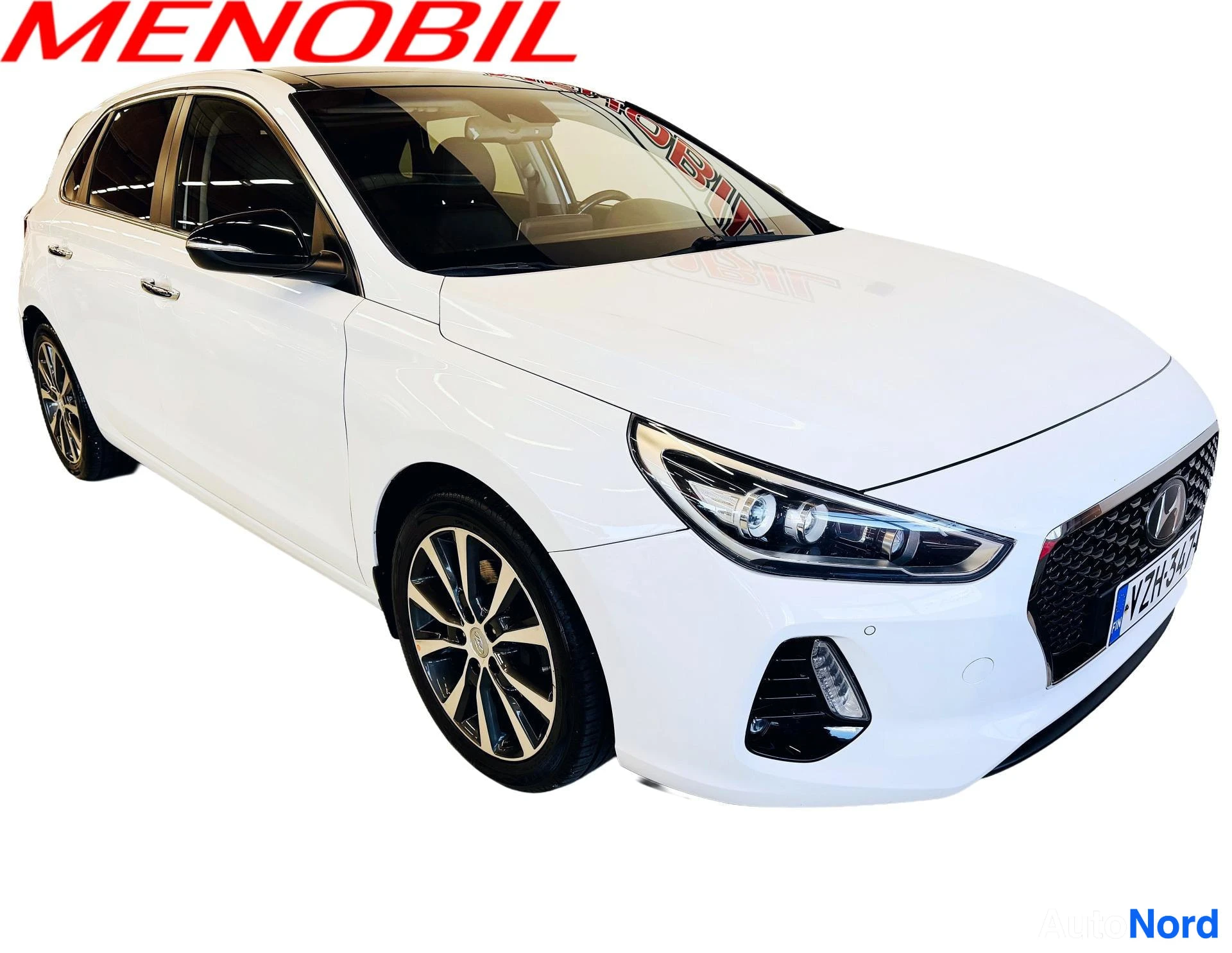 Etuviisto, nokka oikealle: Valkoinen Hyundai i30 kolmiulotteisesta edesta, auto kuvattuna kulmaan vasemmalta puolelta, kojelautapaneeli ja etupyörät näkyvissä