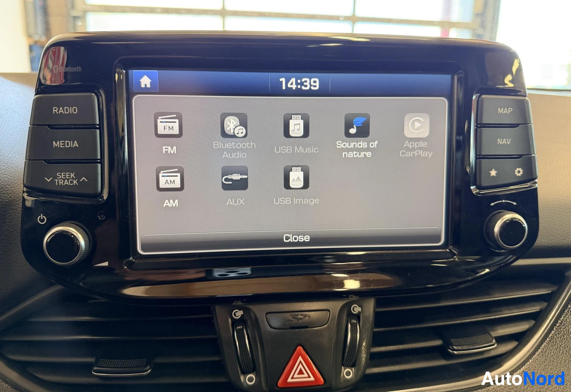 Yksityiskohta: Auton infotainment-näyttö, joka näyttää mediatoiminnot: FM, AM, Bluetooth Audio, USB Music, Sounds of nature ja Apple CarPlay. Käyttöliittymässä näkyvät RADIO,