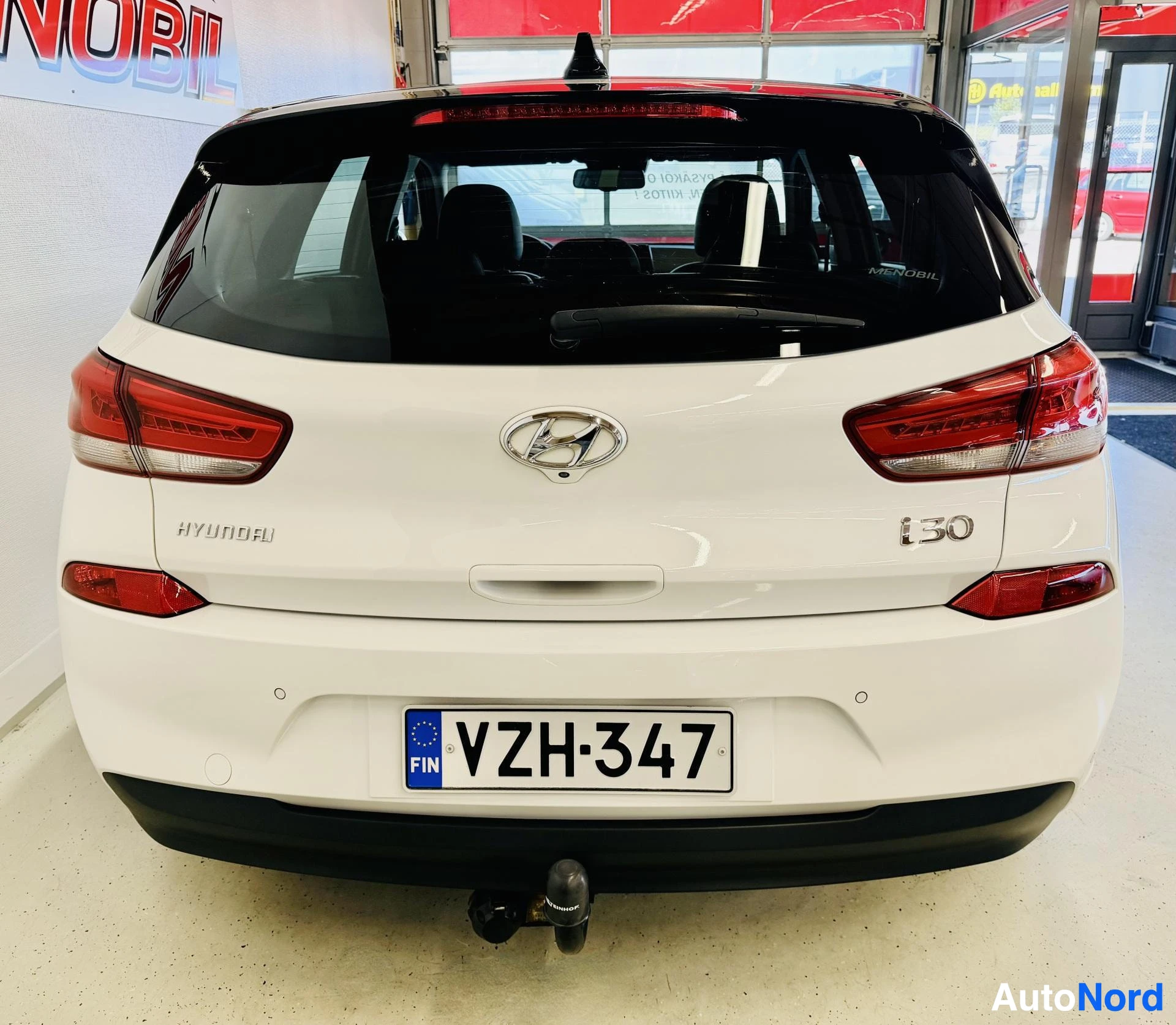 Takaa: Valkoinen Hyundai i30 takaosasta, rekisterinumero näkyy selvästi, vetokoukku näkyy alapuolella
