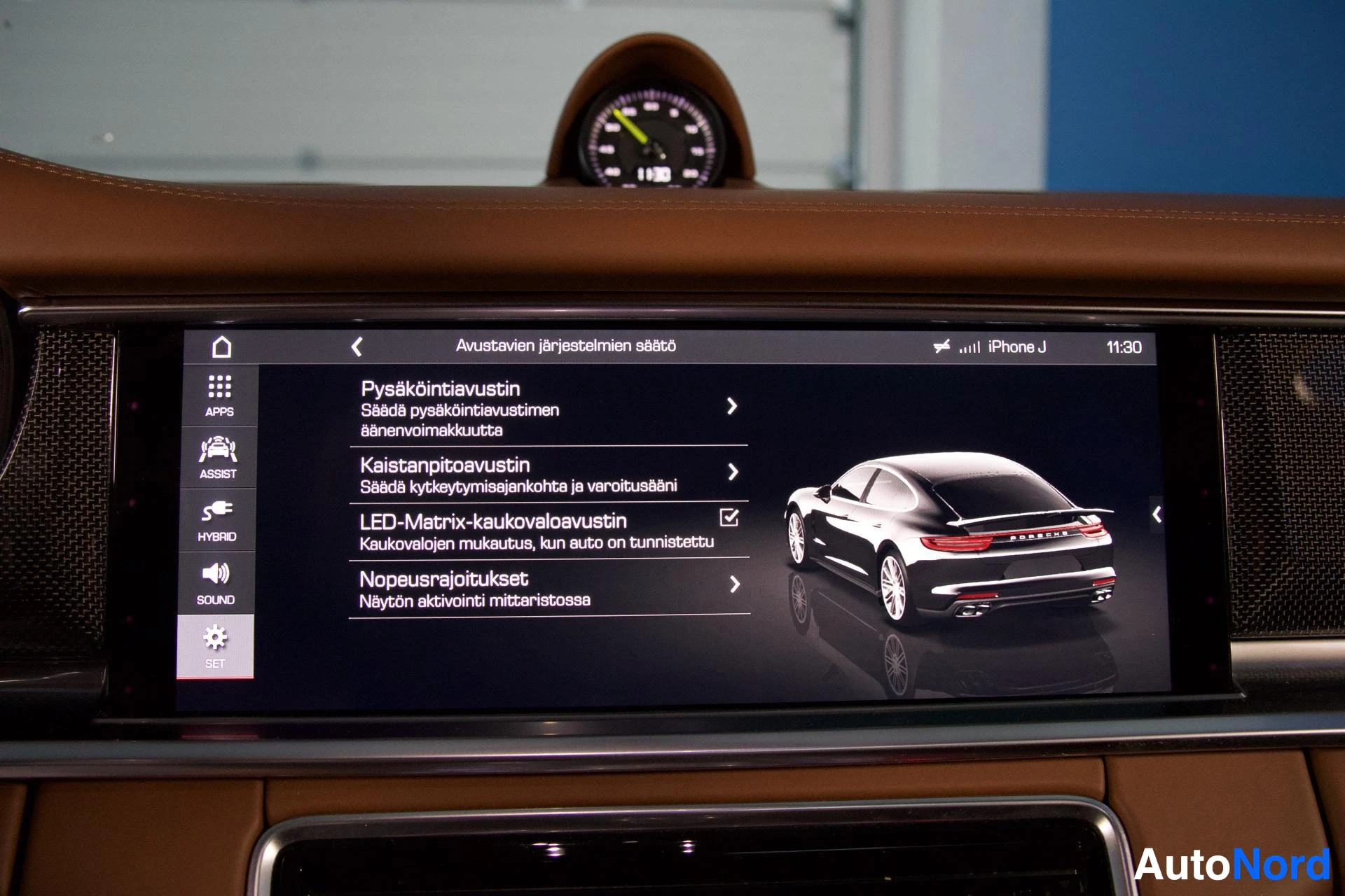 Ohjaamo: Lähikuva auton kojelaudan infotainment-näytöstä, jossa näkyy suomenkielinen valikko kuljettajan apujärjestelmille. Näytöllä on valittavissa "Pysäköintiavustin",