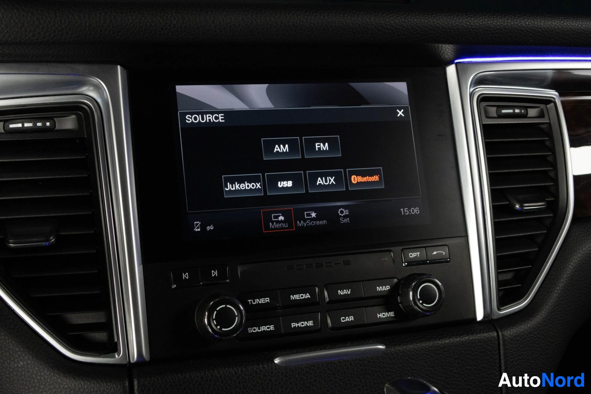 Ohjaamo: Lähikuva auton keskinäytöstä, jossa näkyy medianlähdevalikko AM-, FM-, Jukebox-, USB-, AUX- ja Bluetooth-vaihtoehdoilla.