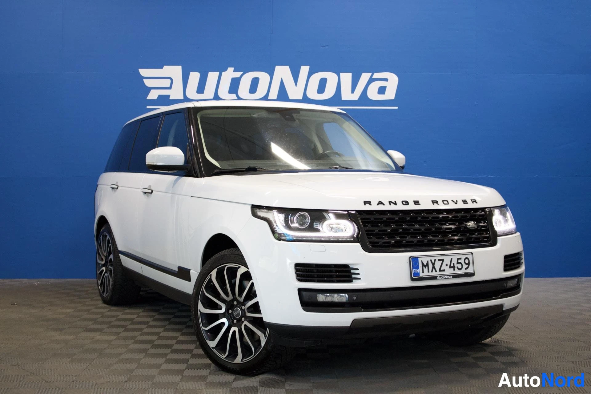 Etuviisto, nokka oikealle: Valkoinen Land Rover Range Rover edestä ja hieman vasemmalta viistosti kuvattuna. Rekisterikilpi "" on näkyvissä