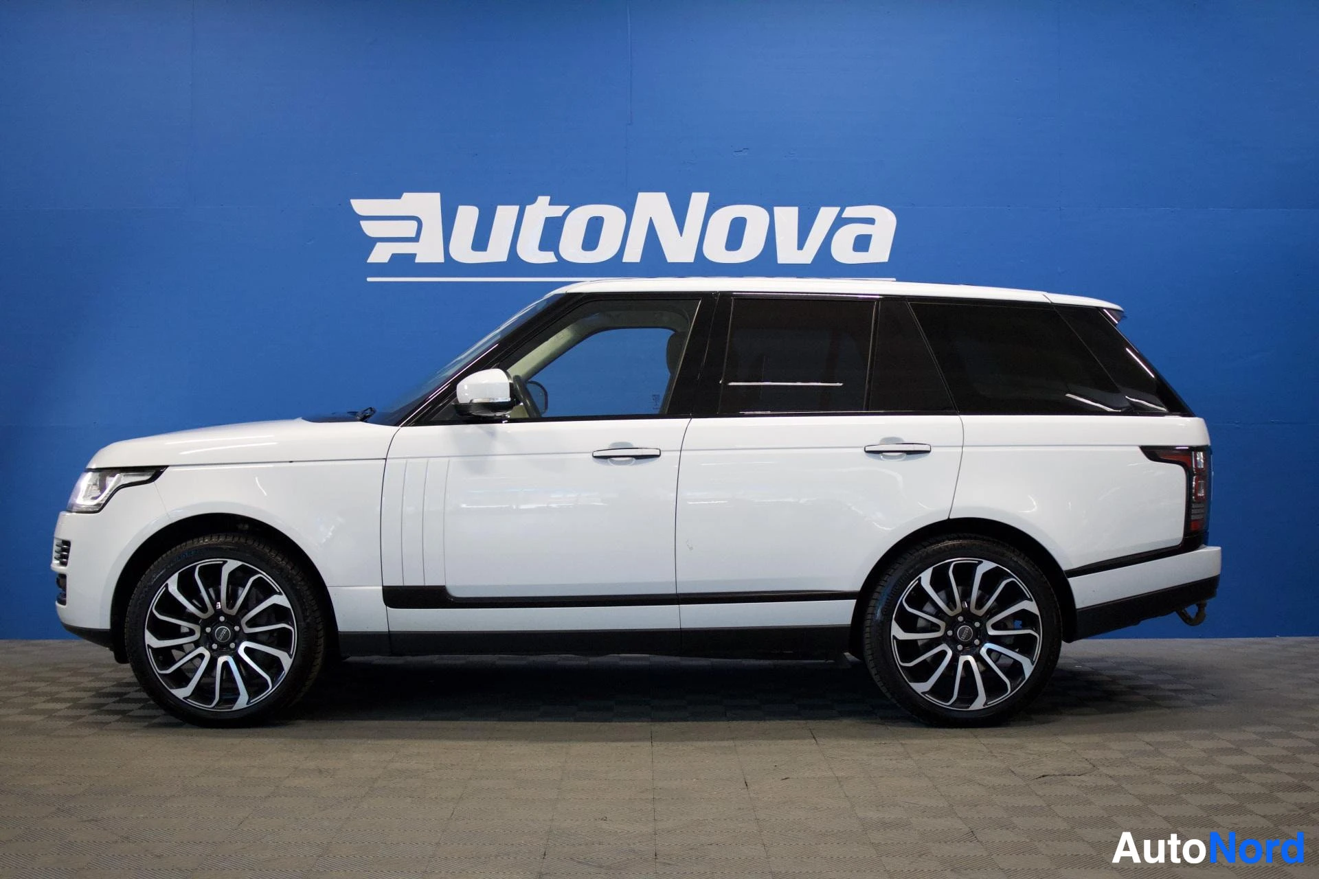 Sivulta: Valkoinen Land Rover Range Roverin profiilikuva sivulta, kuvauspaikkana AutoNova-autoliike.
