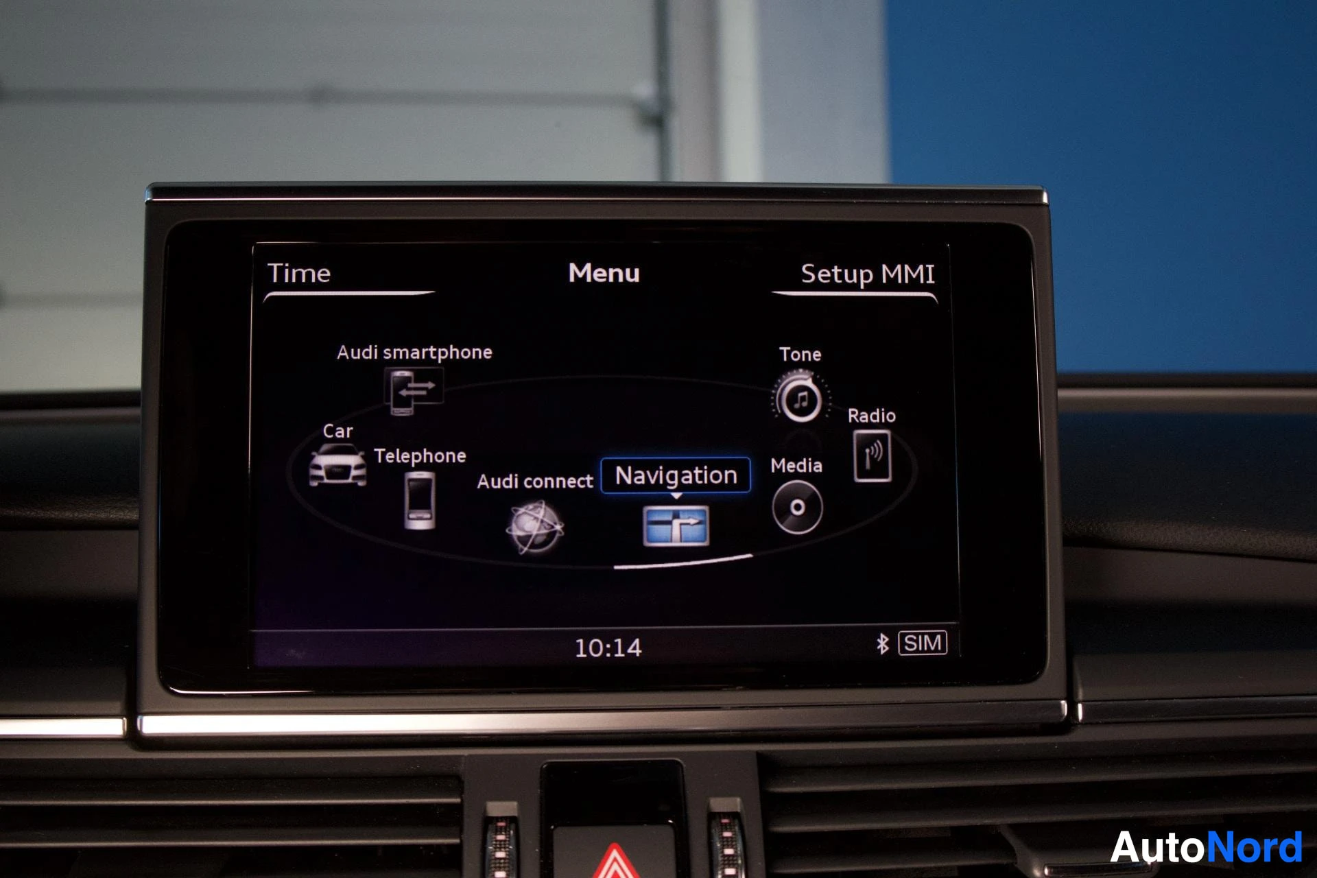 Yksityiskohta: Auton kojelaudassa on keskellä näyttö, joka näyttää "Navigation"-valikon. Näytöllä on myös valinnat "Audi smartphone", "Car", "Telephone", "Audi connect", "Radi