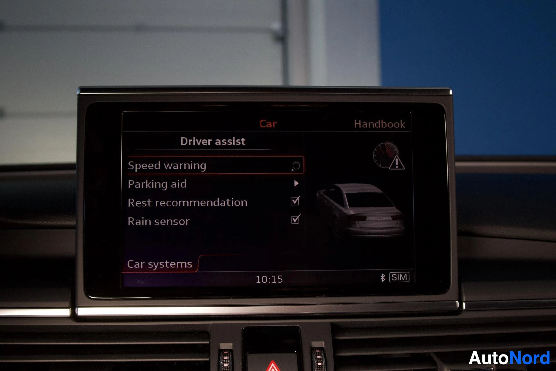 Yksityiskohta: Ajoneuvon näytöllä näkyy auton asetukset, joissa on vaihtoehtoja kuten "Speed warning", "Parking aid", "Rest recommendation" ja "Rain sensor".