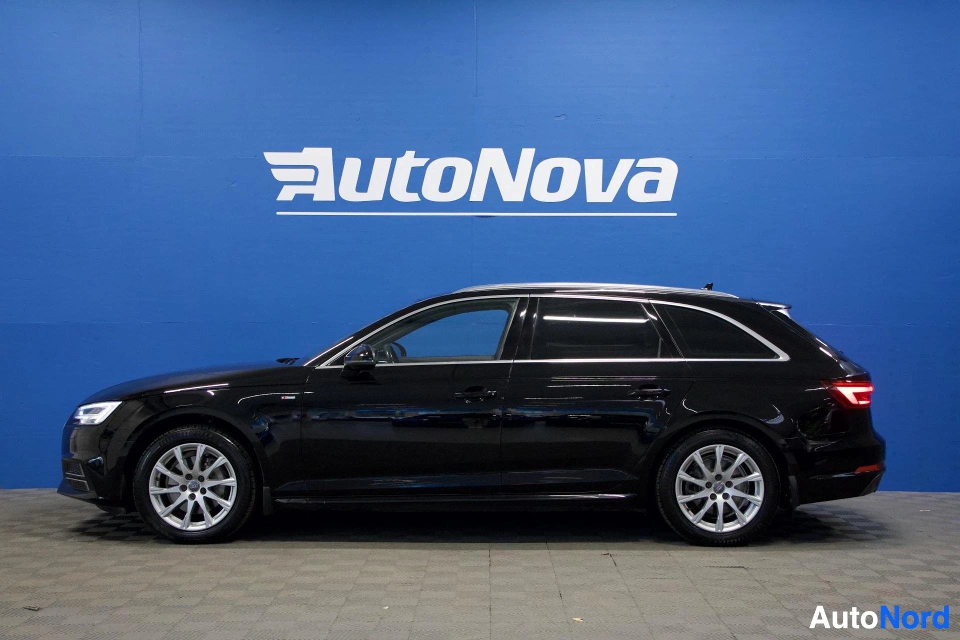 Sivulta: Musta Audi A4 Avant -farmari sivusta katsottuna, valkoinen tausta ja AutoNova-logo näkyvillä.
