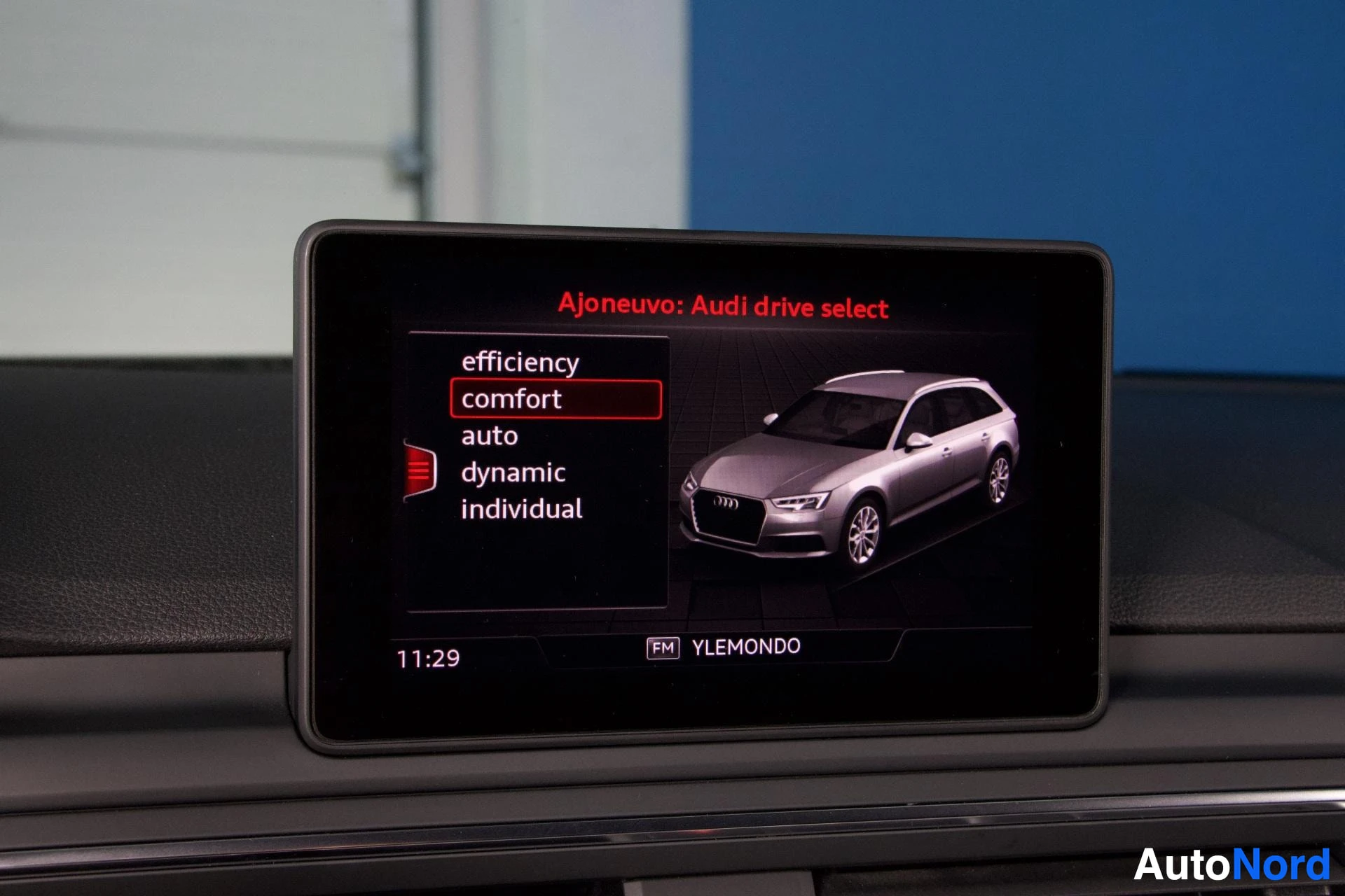 Yksityiskohta: Auton infotainment-näyttö näyttää Audi drive select -valikkoa, jossa comfort-asetusta on valittu. Näytöllä näkyy auto-kuva, ajonopeusaika 11:29 ja FM-radio.
