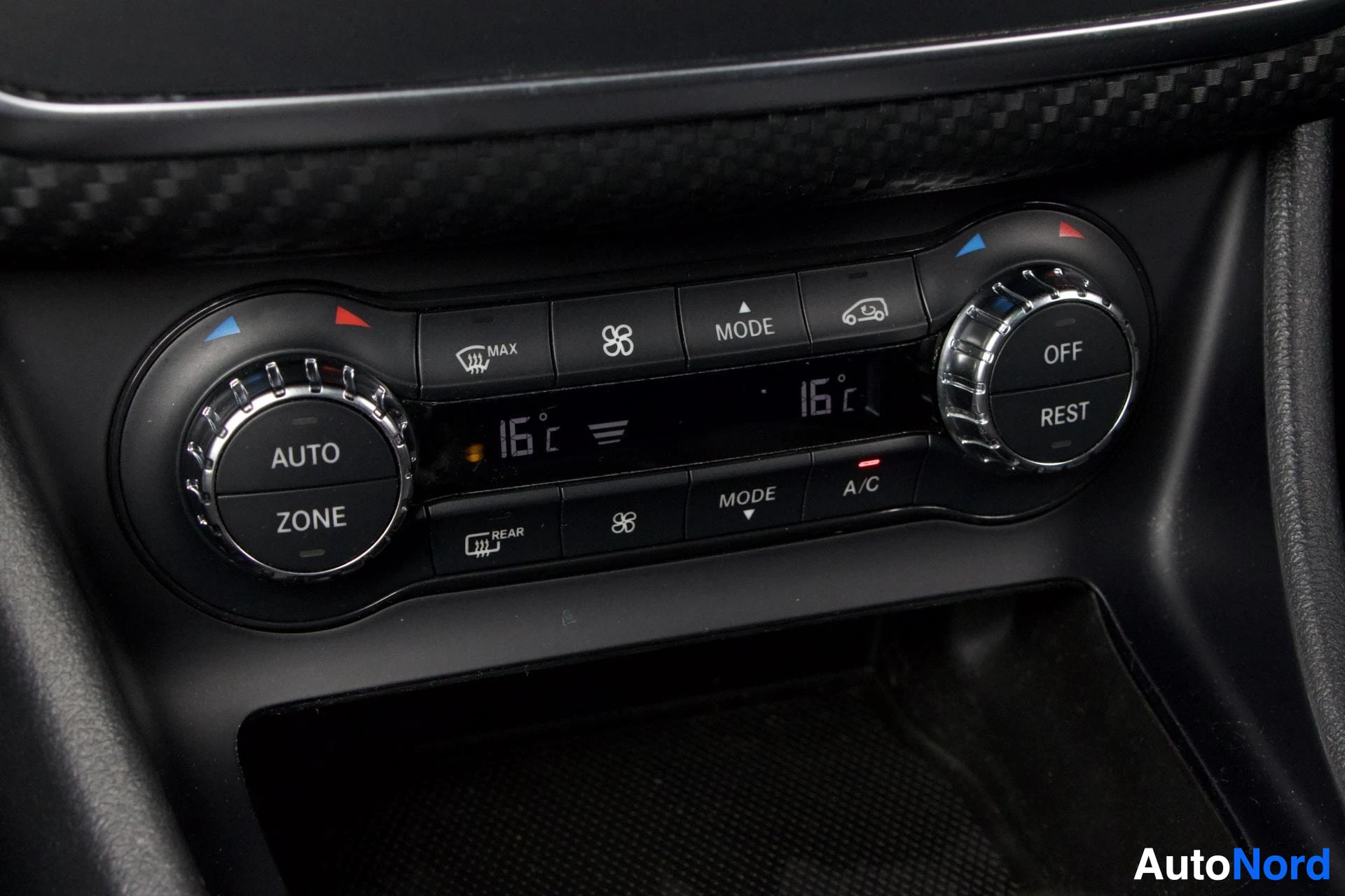 Muu: Musta merkki: Mercedes-Benzin ilmastointipaneeli, jossa näkyvät AUTO-, ZONE-, OFF- ja REST-napit sekä lämpötila 16 °C näytöillä.
