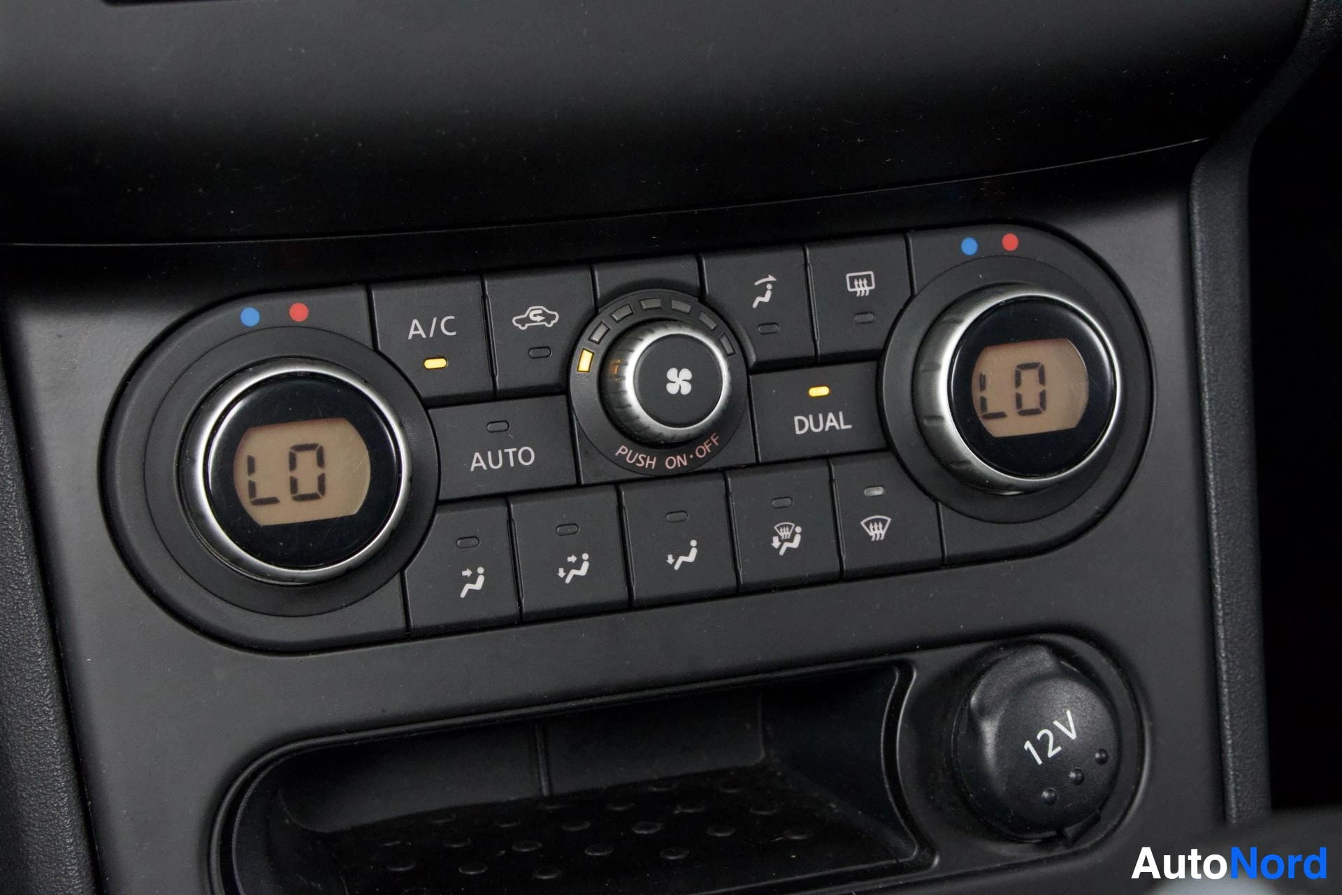 Yksityiskohta: Ilmastointi- ja lämmitysjärjestelmän ohjaus: DUAL-säätö, AUTO-tila, A/C, ilmanvaihdon painike ja sisäänottovalitsin.