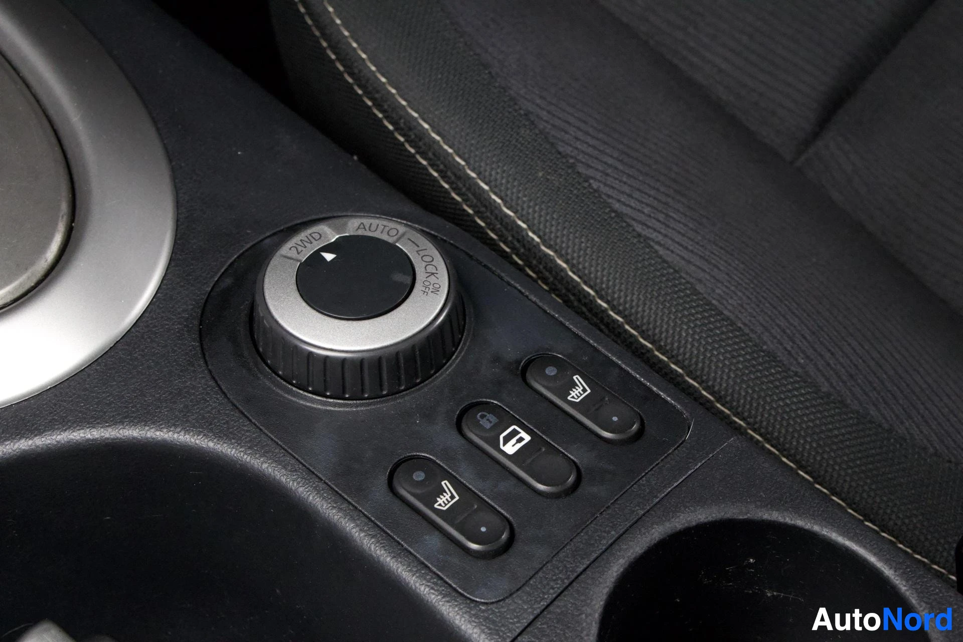 Yksityiskohta: Istumisen säädöt oikealla puolella: kolme painiketta lämmitettäville istuimille ja yksi AUTO-säätöpyörä.