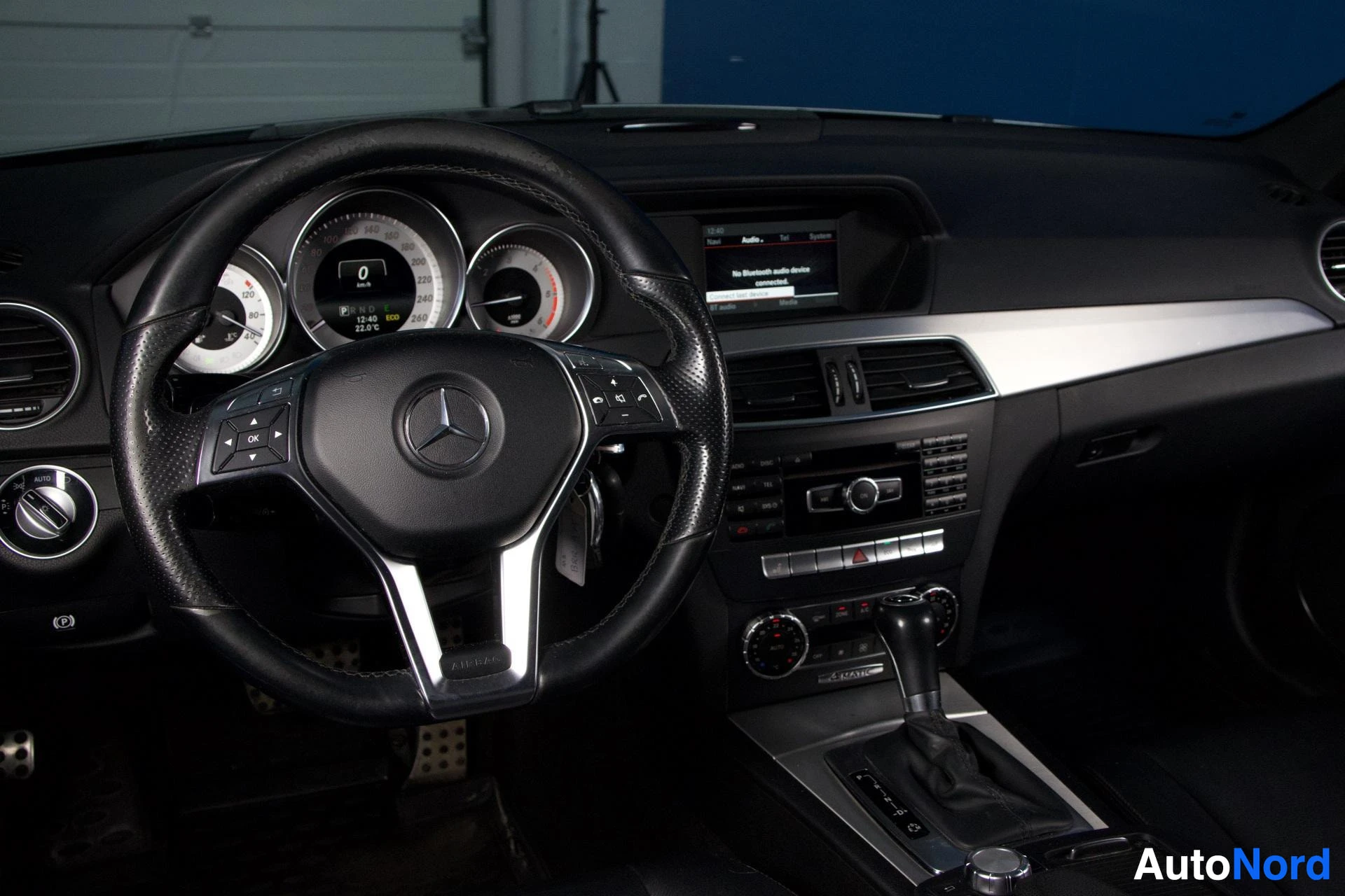 Ohjaamo: Ohjaamo sisäosa: musta-valkoinen nahkainen ohjauspyörä Mercedes-logolla, kolme mittaria, monivärinen näyttö, valkea värisuoja oikealla, mustat ja valkoiset sisu