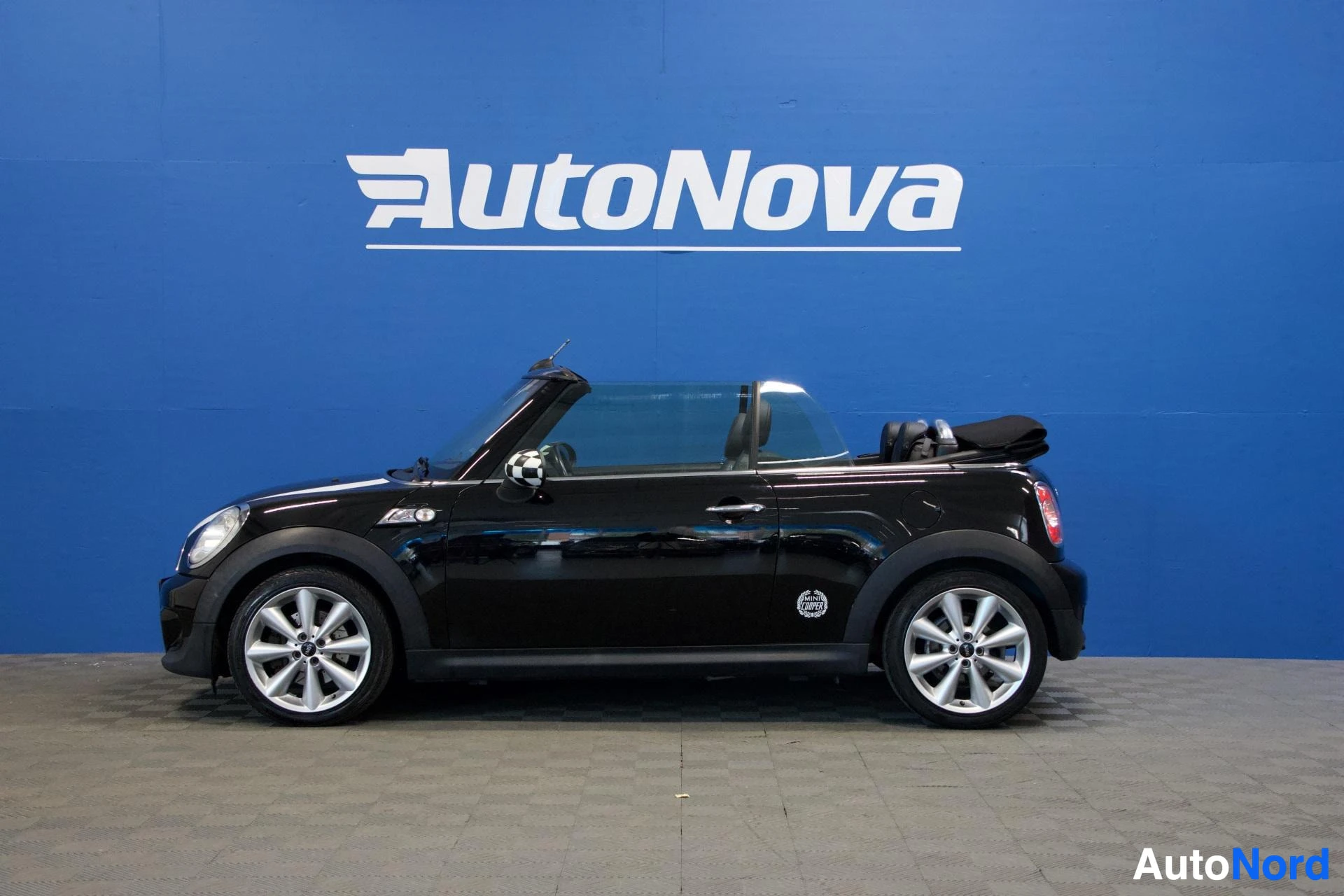 Sivulta: Musta Mini Cooper avoauto sivusta, katto auki, valkoiset vanteet, pituuskuva