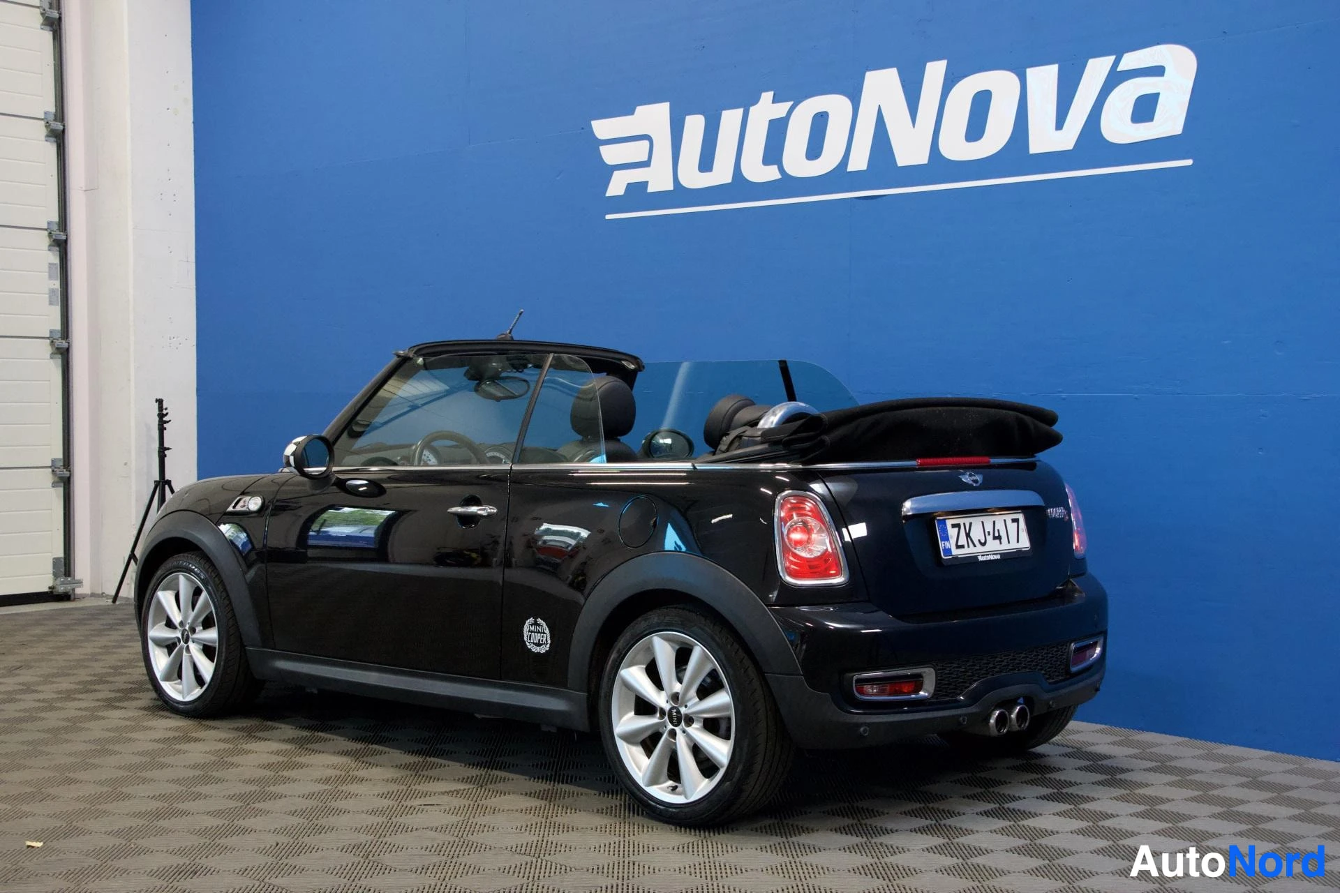 Takaviisto: Musta Mini Cooper avoauto sivusta kulmasta, ovi auki, kylki näkyvissä, valkoiset vanteet, rekisterikilpi ZK J417 näkyvissä