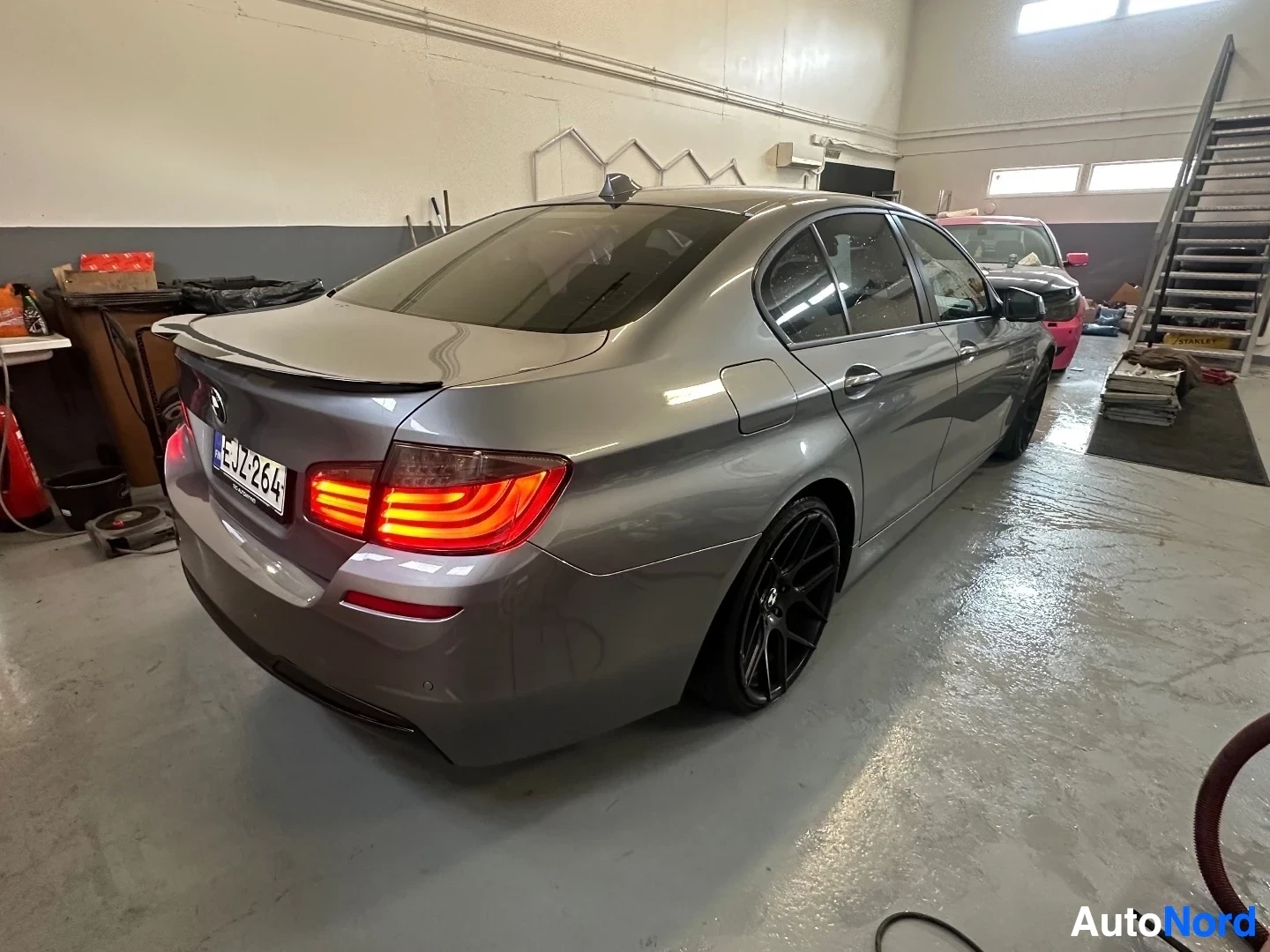 Takaviisto: Hopeanvärinen BMW sedan takaa ja oikealta, punaiset takavalaisimet päällä, rekisterikilvessä LJ18JZF.