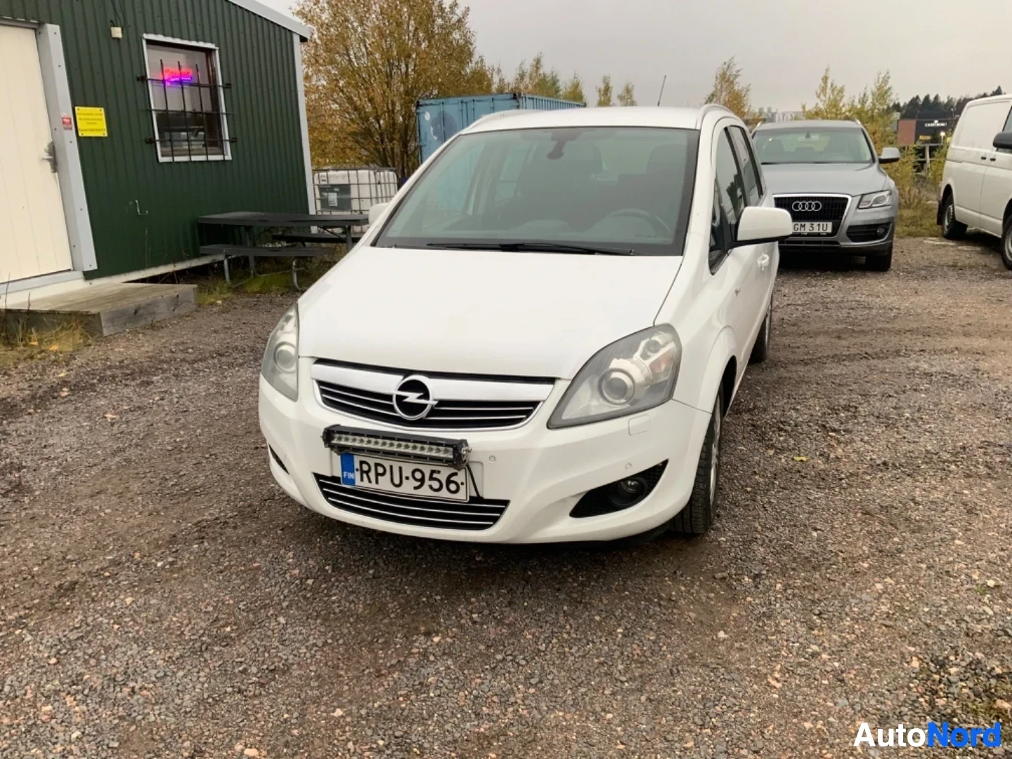 Edestä: Valkoinen perheperhonen etulta, rekisterikilvessä, Opel-tunnus etuosassa