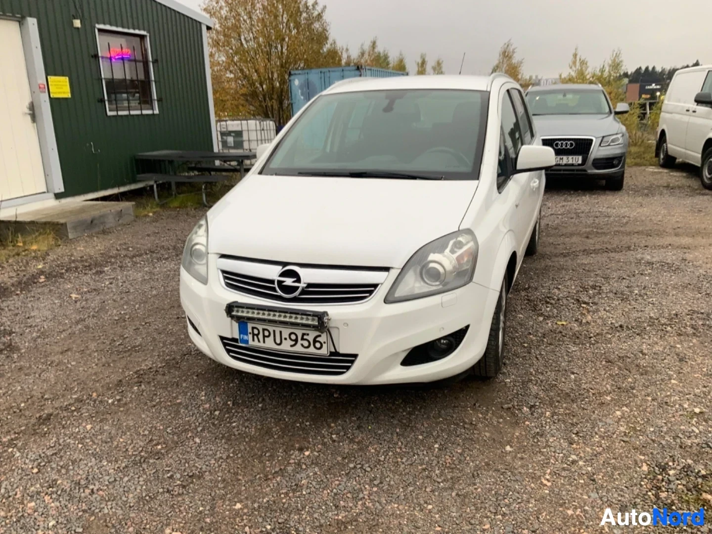 Edestä: Valkoinen perheperhonen etulta, rekisterikilvessä, Opel-tunnus etuosassa