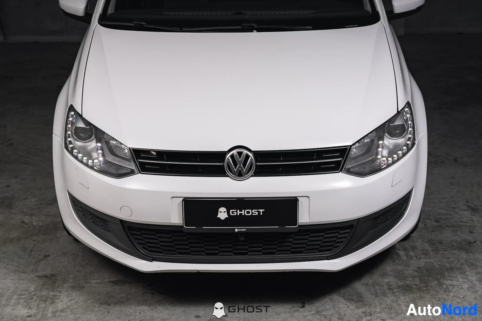 Edestä: Valkoinen Volkswagen Polo, lähikuva keulasta, säleikkö ja ajovalot