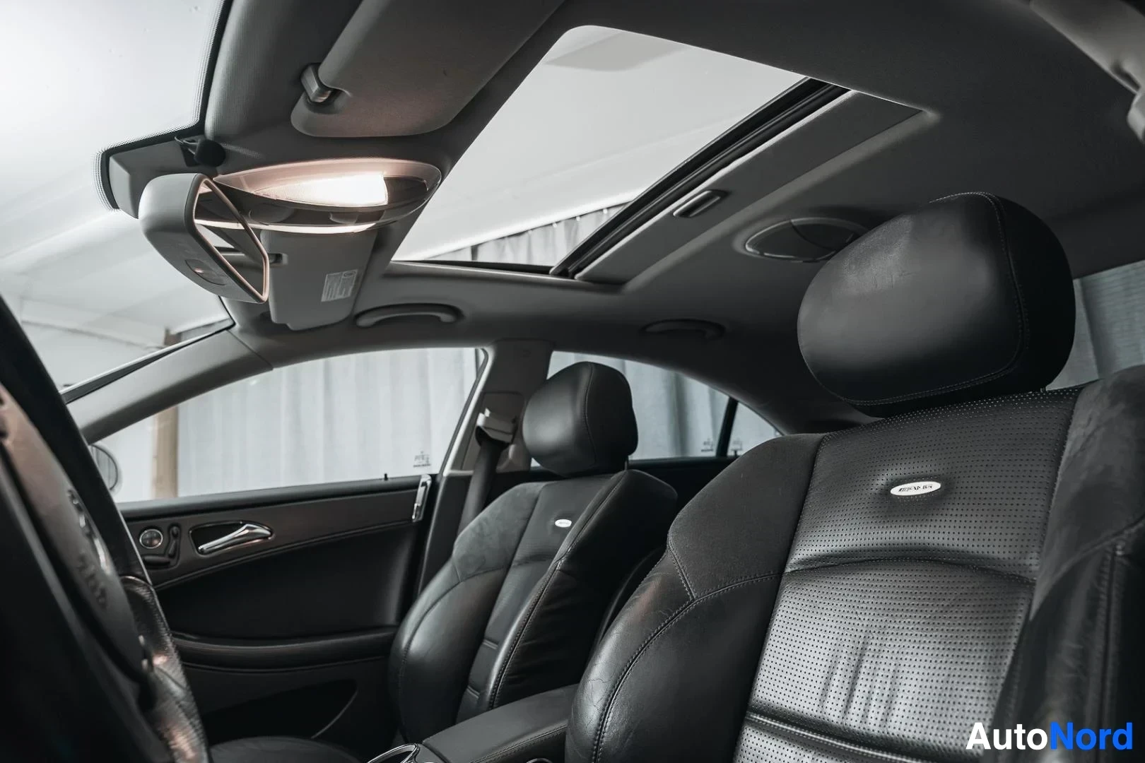 Etuistuimet: Valkoinen Mercedes-Benz CLS 63 AMG, mustat nahkaverhoillut etuistuimet matkustajan puolelta, kattoluukku