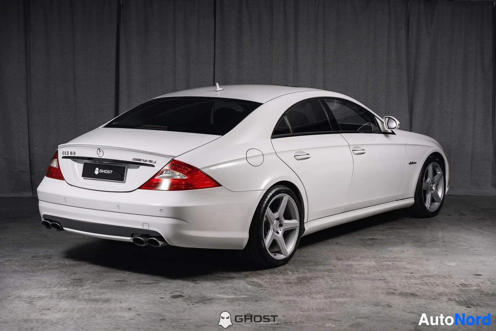 Takaviisto: Valkoinen Mercedes-Benz CLS 63 AMG, koko ajoneuvo näkyvissä, coupémainen sedan-kori, studiotausta