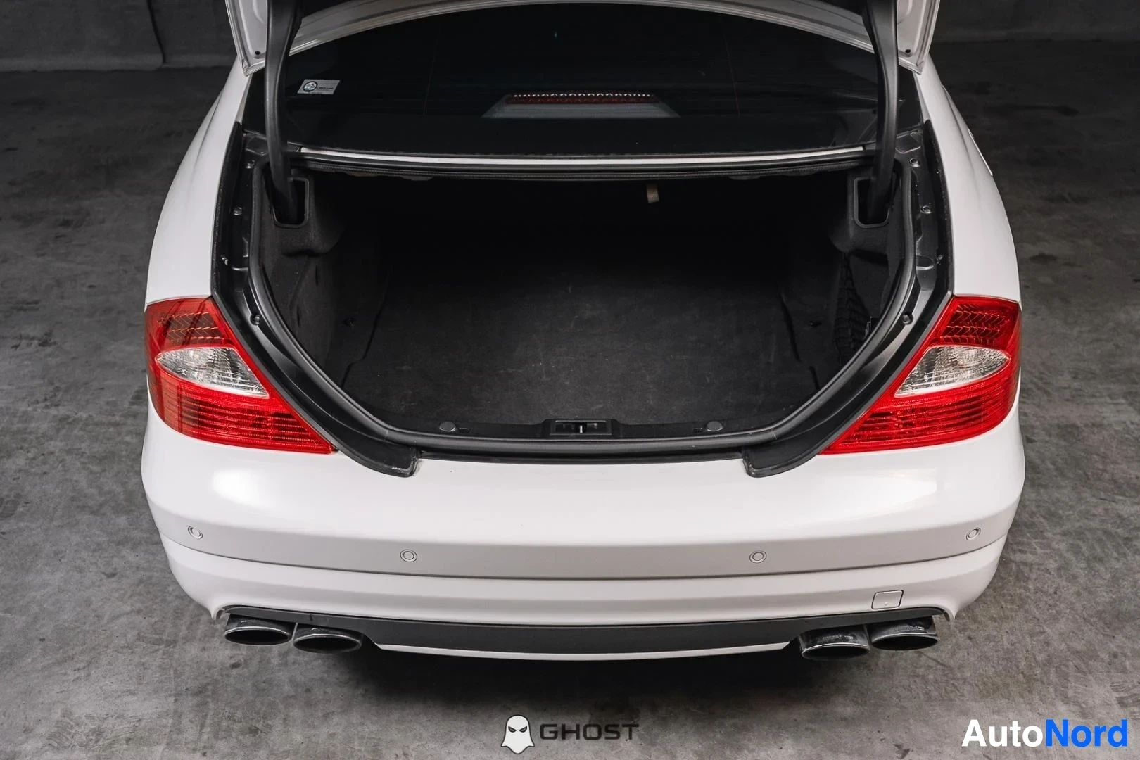 Tavaratila: Valkoinen Mercedes-Benz CLS 63 AMG, avattu takaluukku ja tavaratila