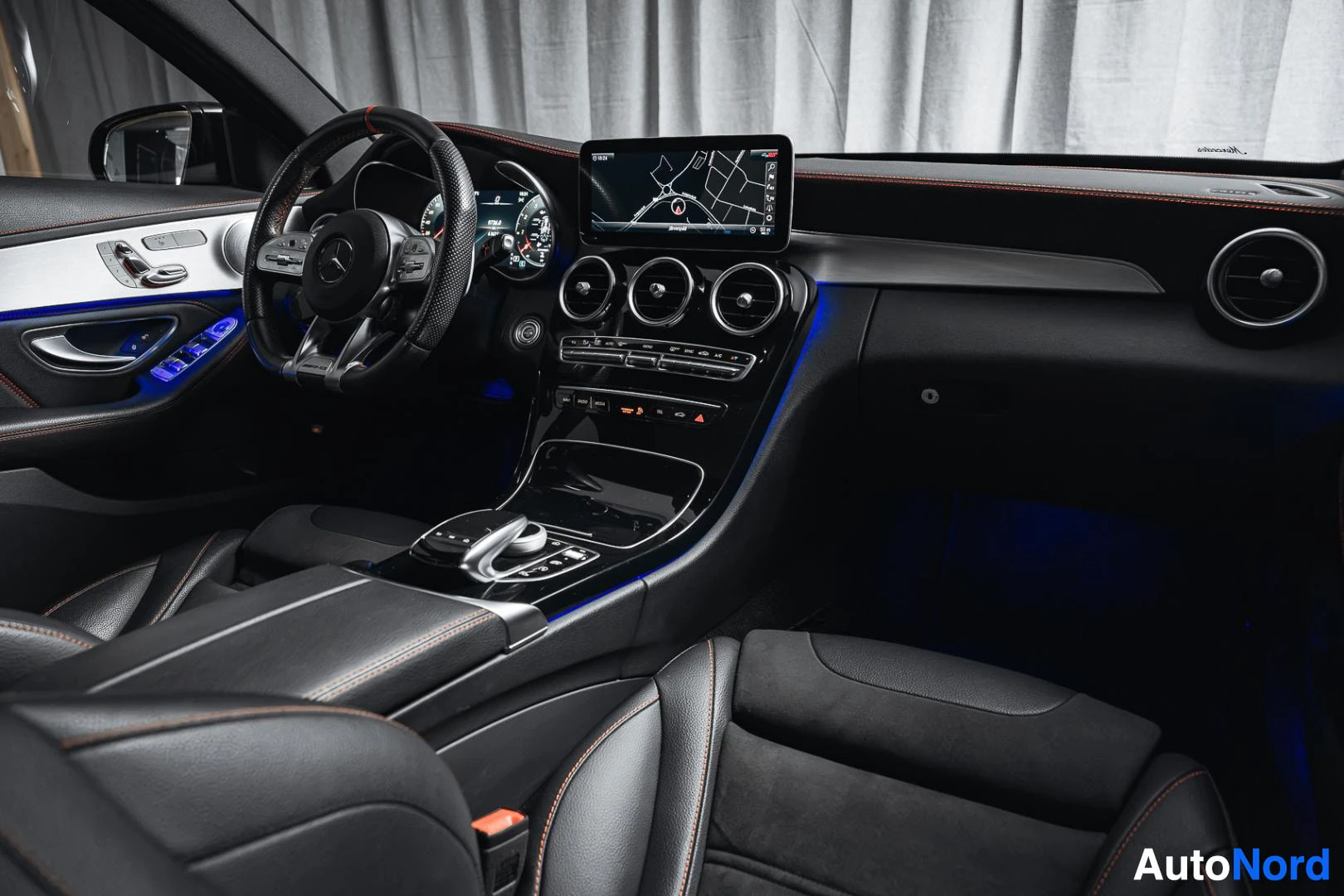 Ohjaamo: Musta Mercedes-Benz C 43 AMG, kojelauta matkustajan puolelta, keskinäyttö ja sininen tunnelmavalaistus