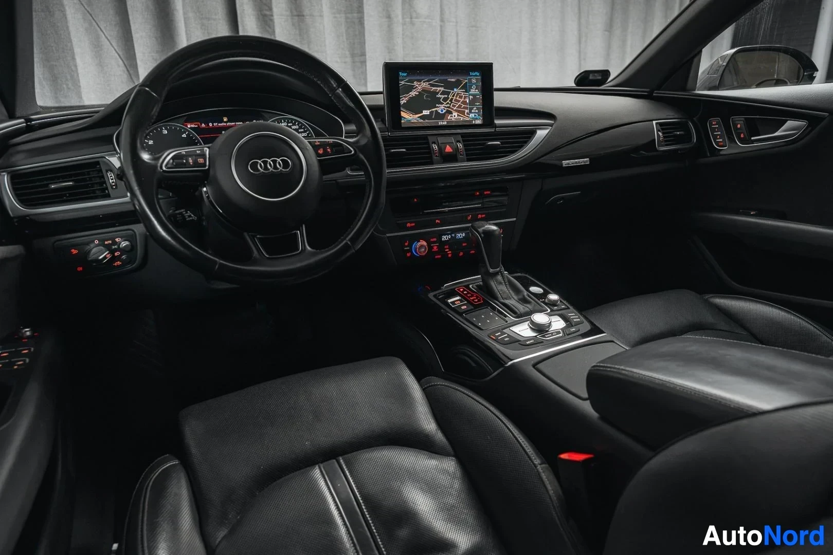Ohjaamo: Musta Audi A7, kojelauta ja ohjauspyörä matkustajan puolelta, musta nahkaverhoilu