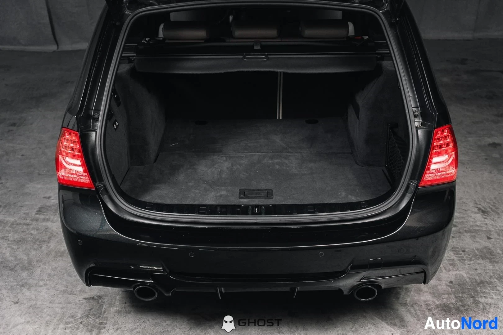Tavaratila: Musta BMW 335i xDrive E91 Touring, avattu takaluukku ja tavaratila