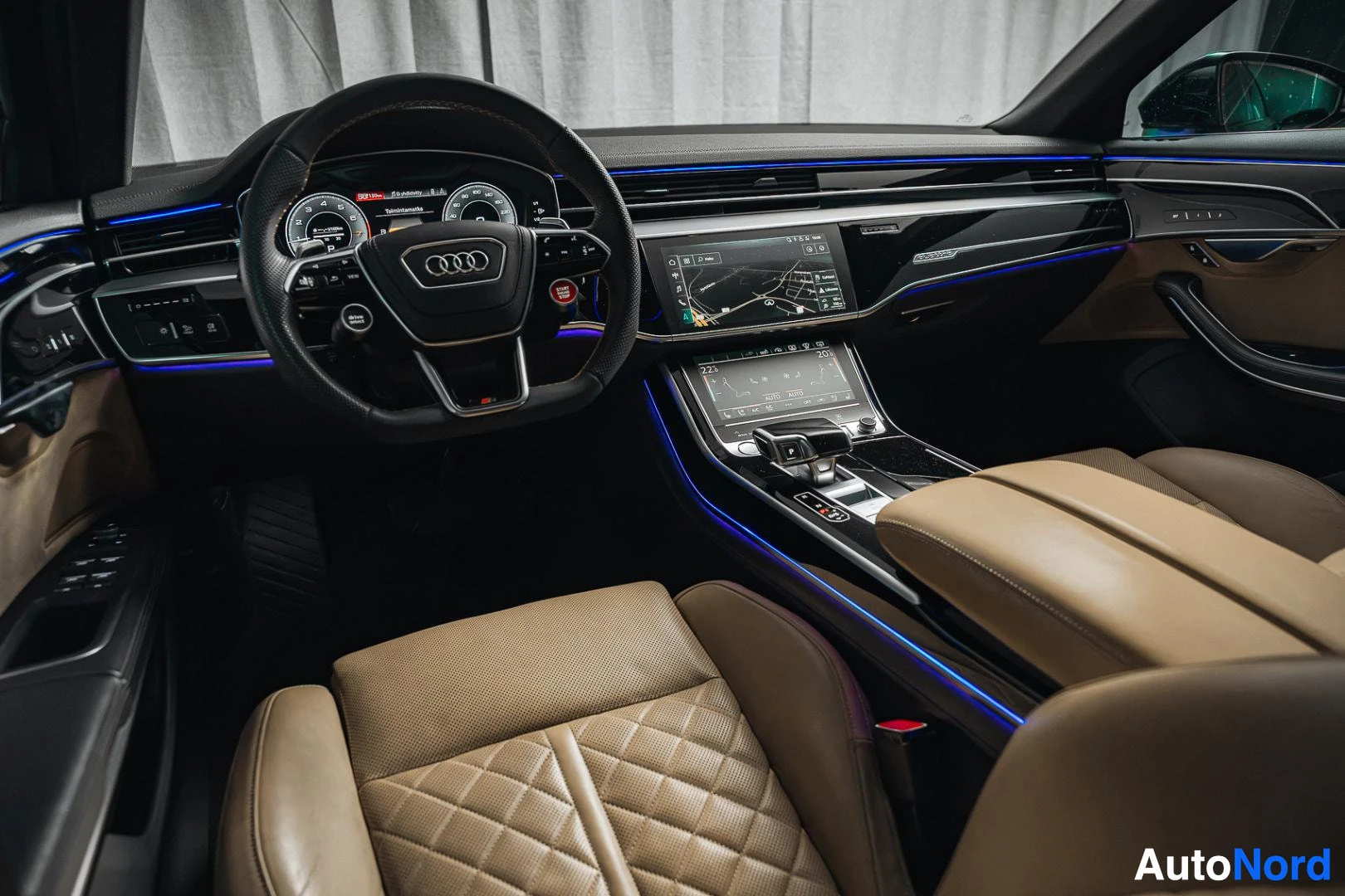 Ohjaamo: Musta Audi A8, kojelauta ja ohjauspyörä matkustajan puolelta, beige nahkaverhoilu